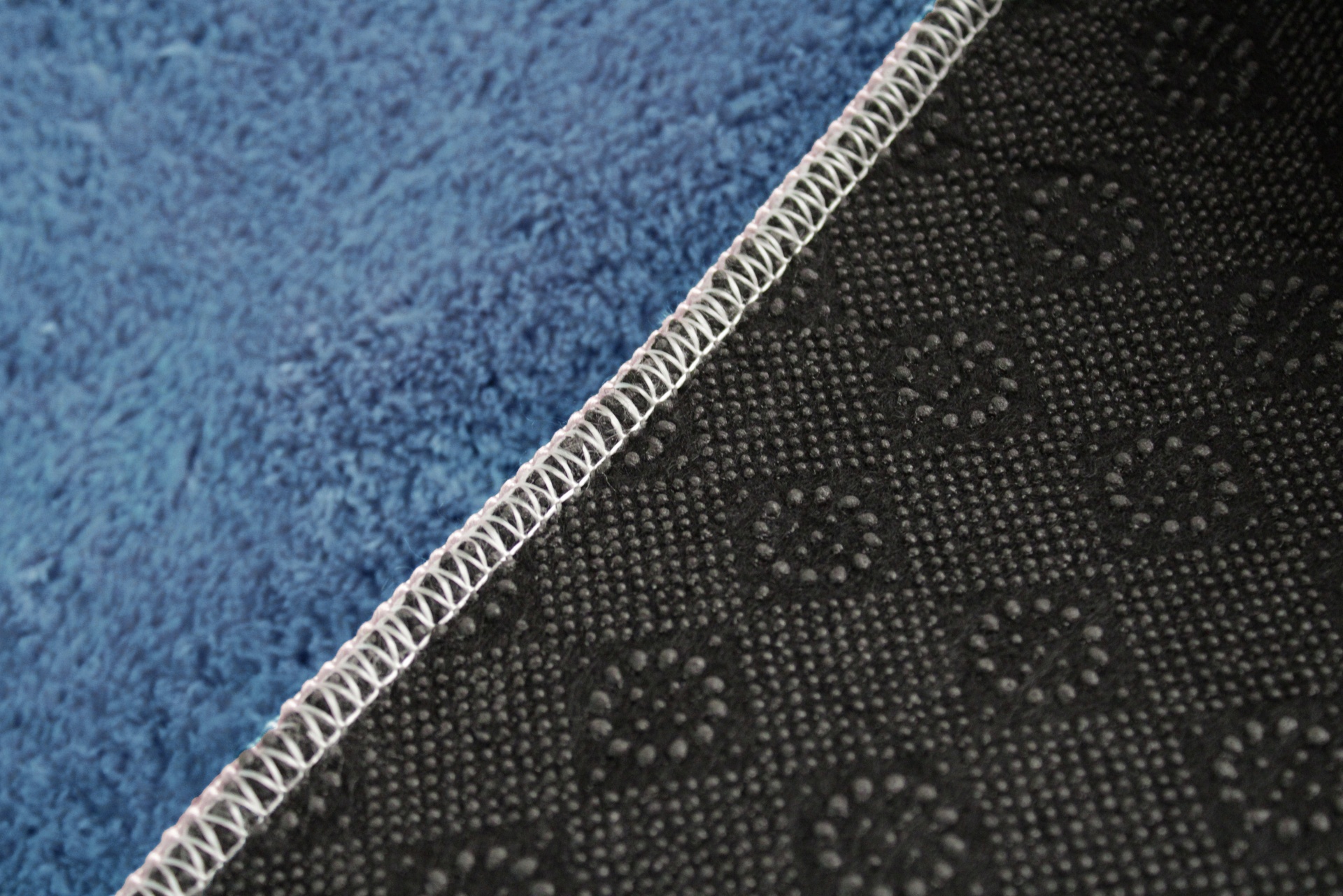 Tapete azul com verso antiderrapante preto com padrão e costura branca