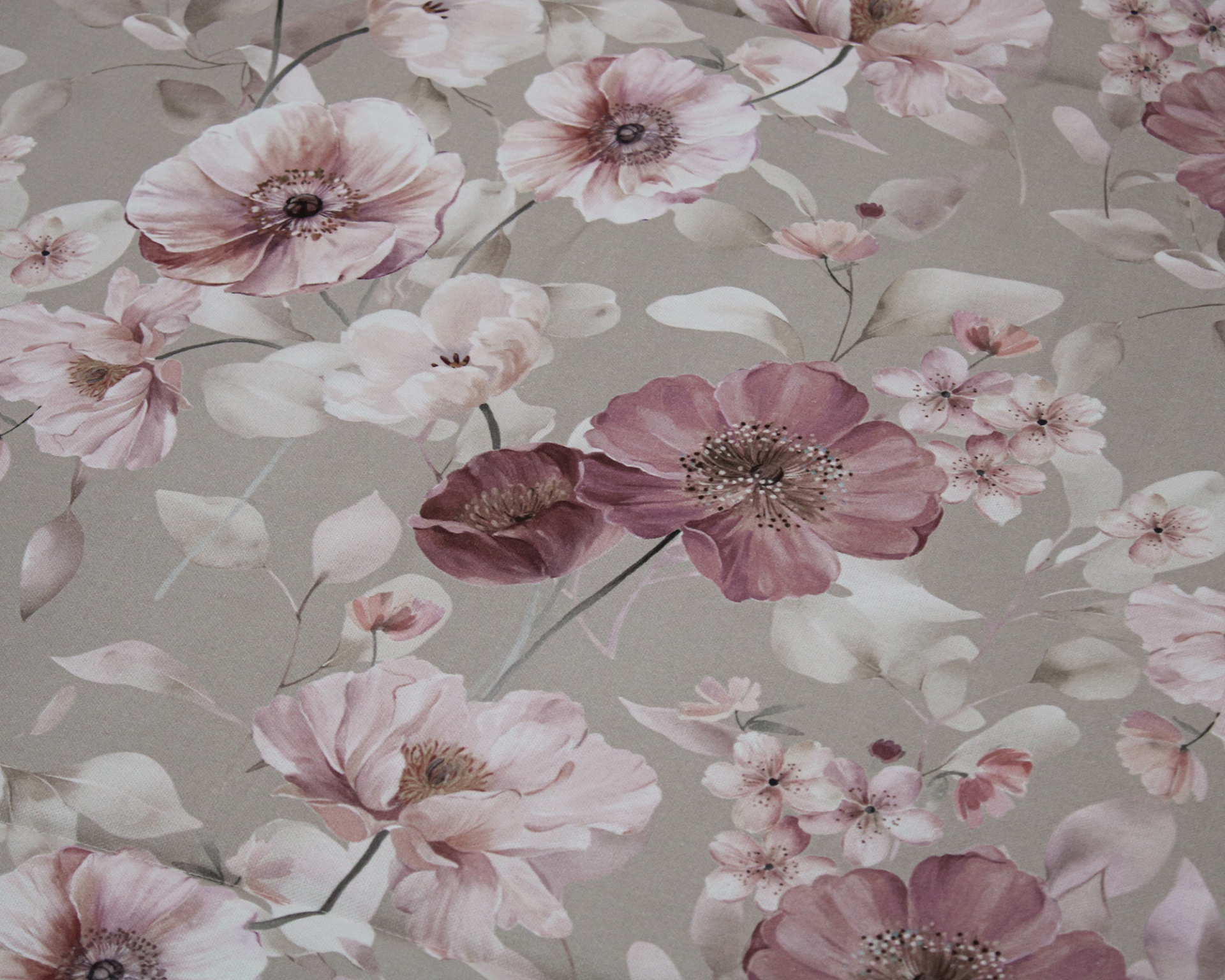 Tecido com padrão floral em tons rosa e lilás sobre fundo cinza