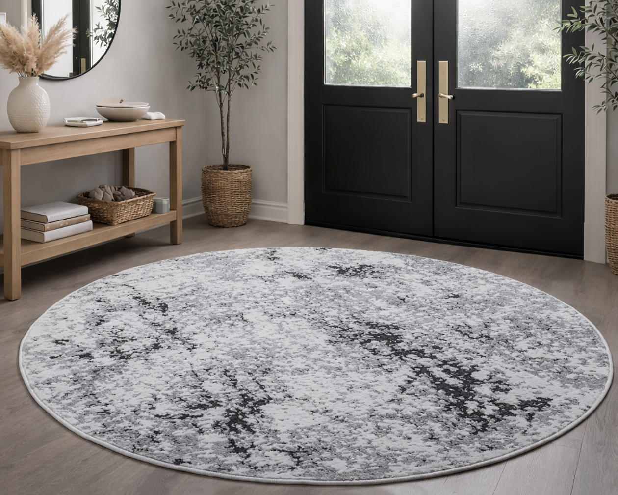 Tapete redondo cinza e branco com padrão abstrato em sala com mesa, plantas e porta preta