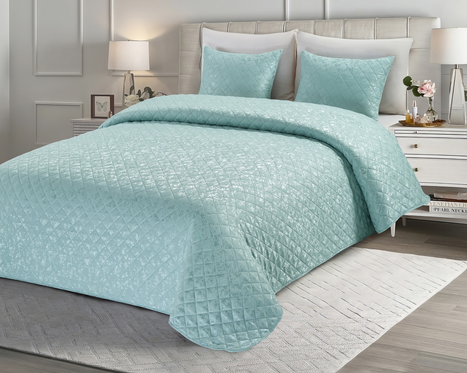 Cama de casal com colcha azul claro acolchoada e almofadas num quarto moderno