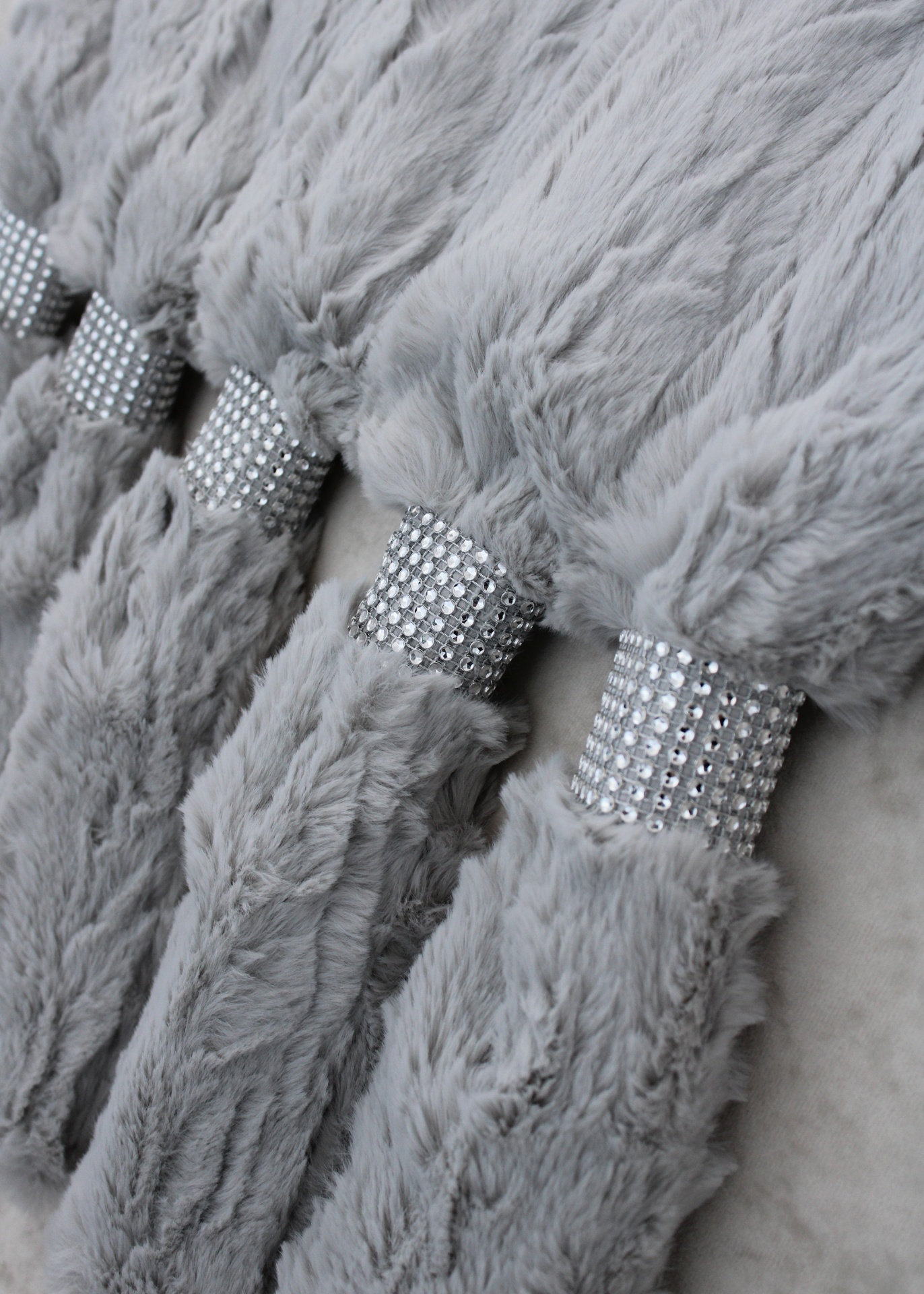 Pulseiras cinza de pelúcia com detalhes prateados