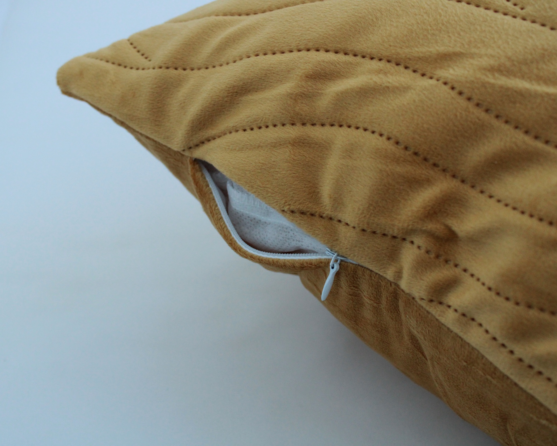 Almofada castanha com padrão de linhas salientes e fecho de correr branco