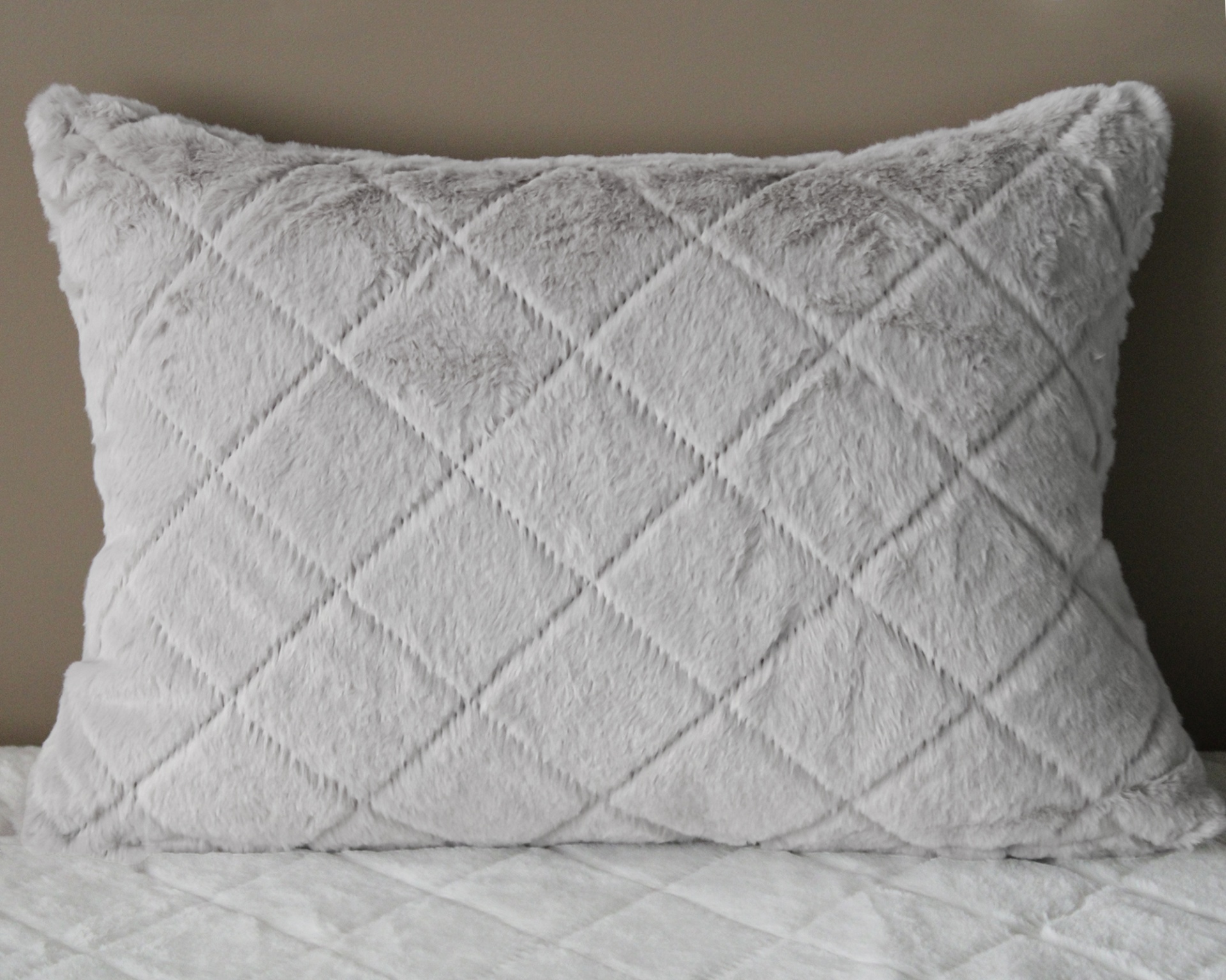 Almofada felpuda cinzenta clara com padrão de losangos