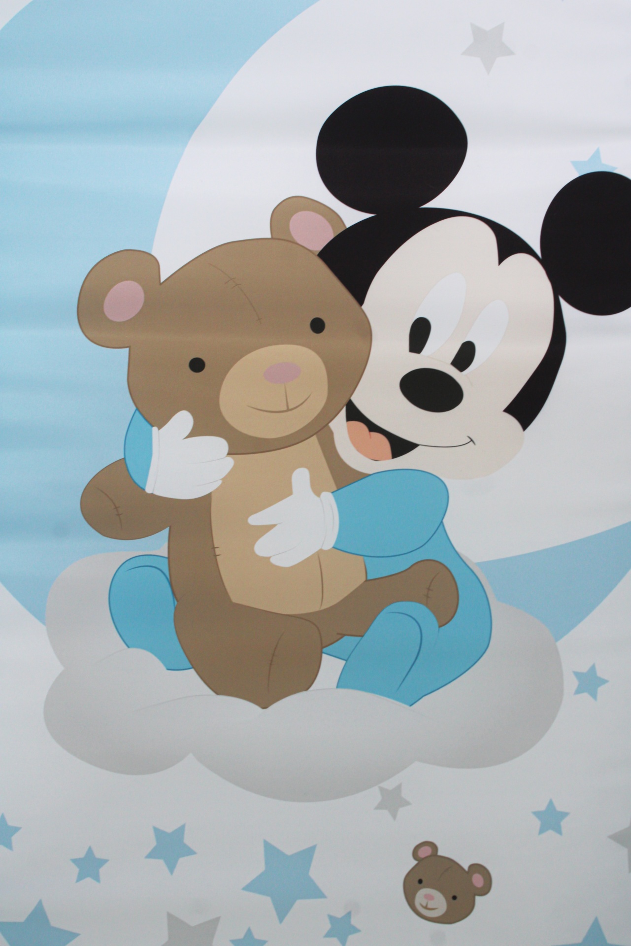Ilustração de bebé Mickey Mouse abraçando ursinho na nuvem com estrelas no fundo