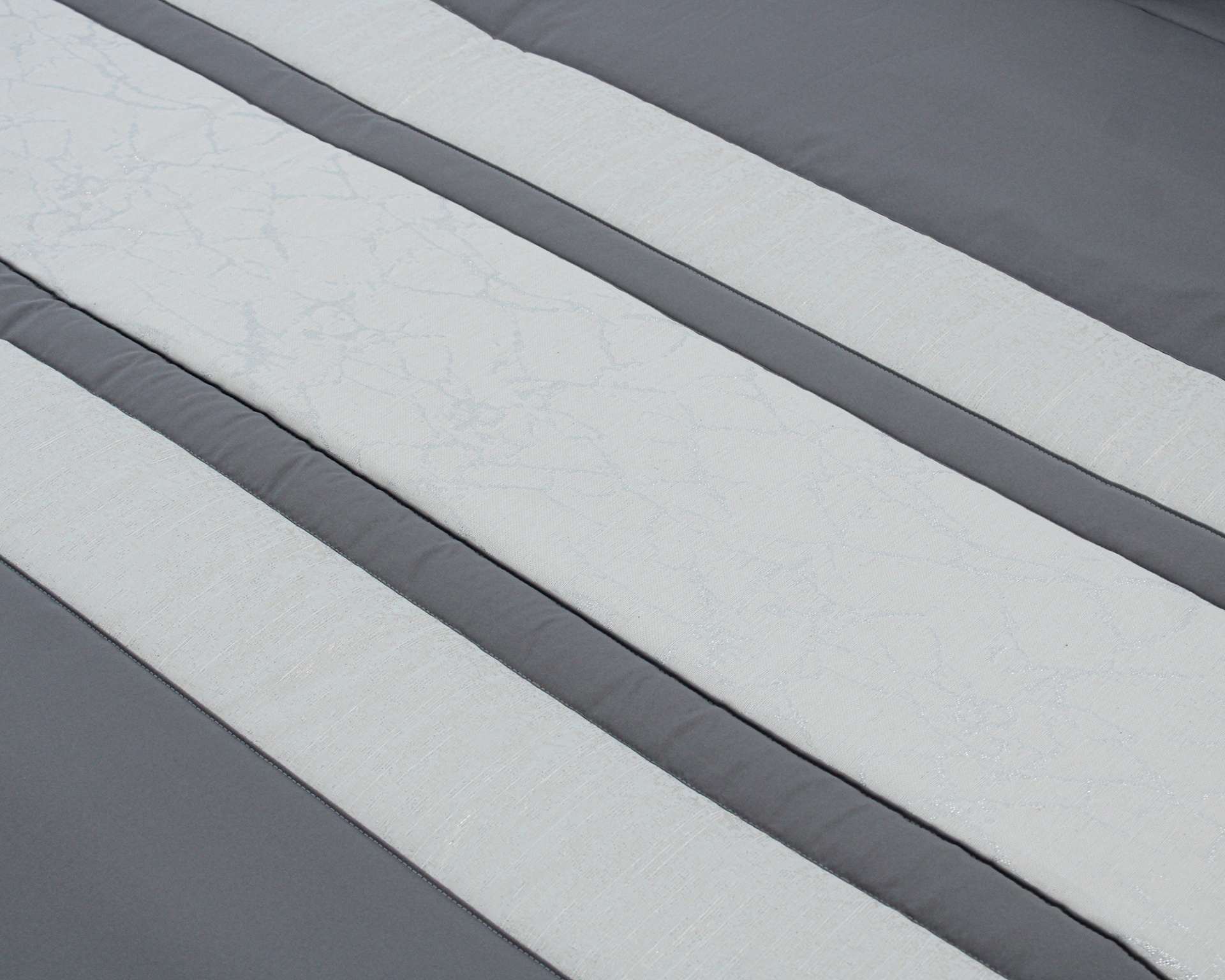 Têxtil cinza com riscas brancas e padrão floral em relevo