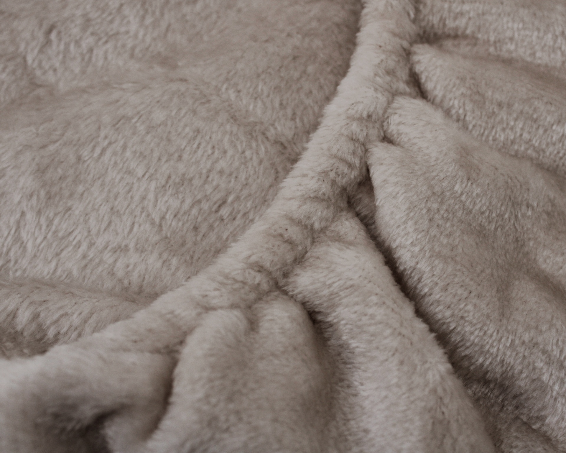 Manta felpuda bege com textura macia e detalhada