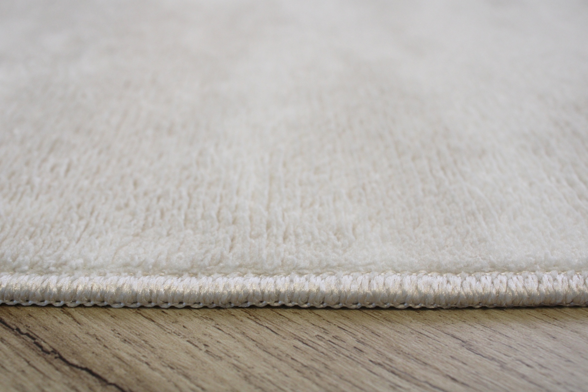 Tapete creme claro macio sobre piso de madeira clara