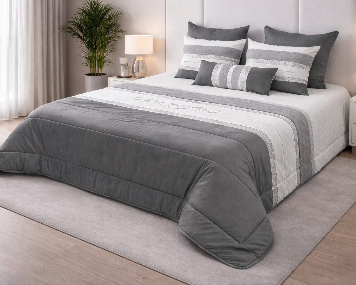 Cama com colcha cinza e branca e almofadas decorativas em quarto moderno