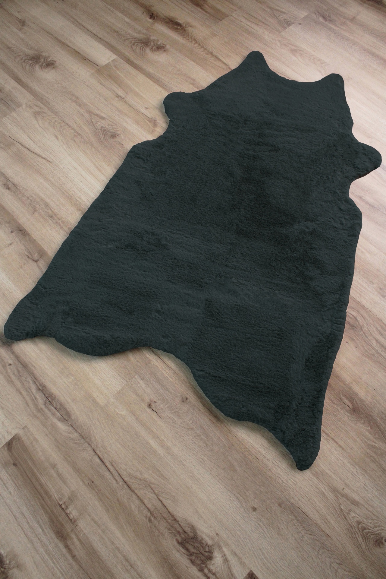 Tapete preto de formato irregular sobre chão de madeira clara