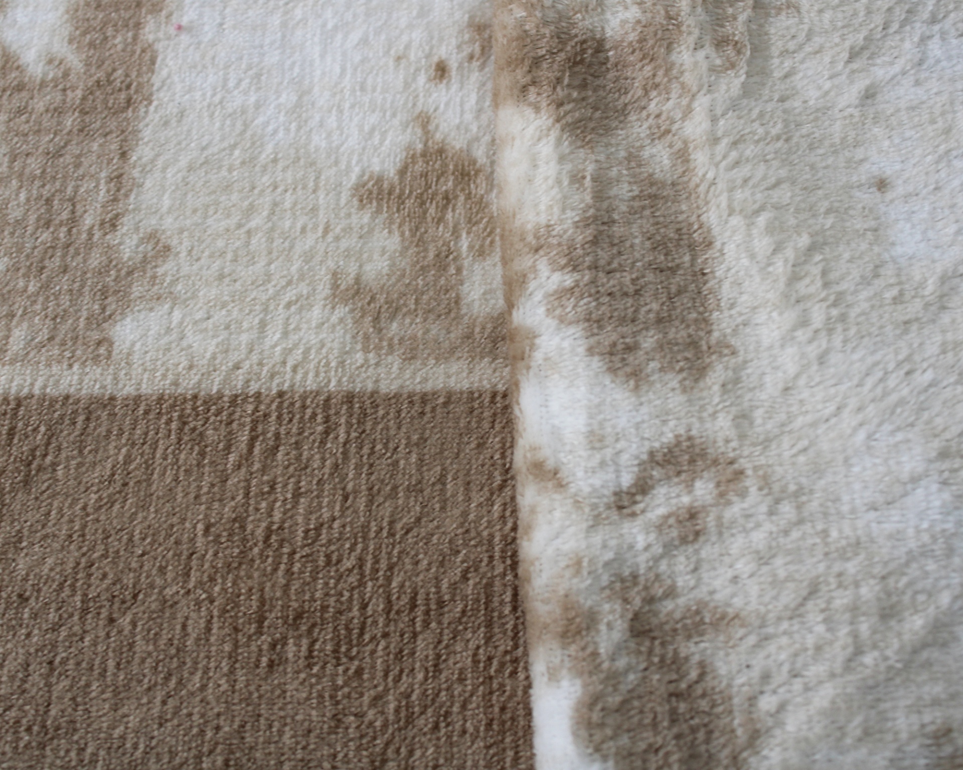 Tapete ou manta bege e castanho com padrão geométrico e textura felpuda