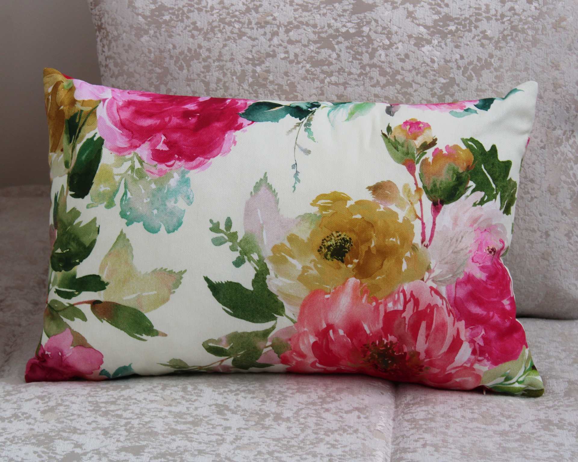 Almofada decorativa floral sobre sofá bege claro