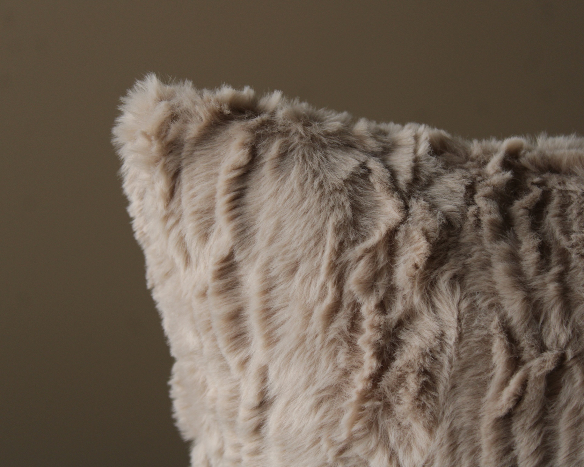 Almofada felpuda bege com textura em fundo castanho