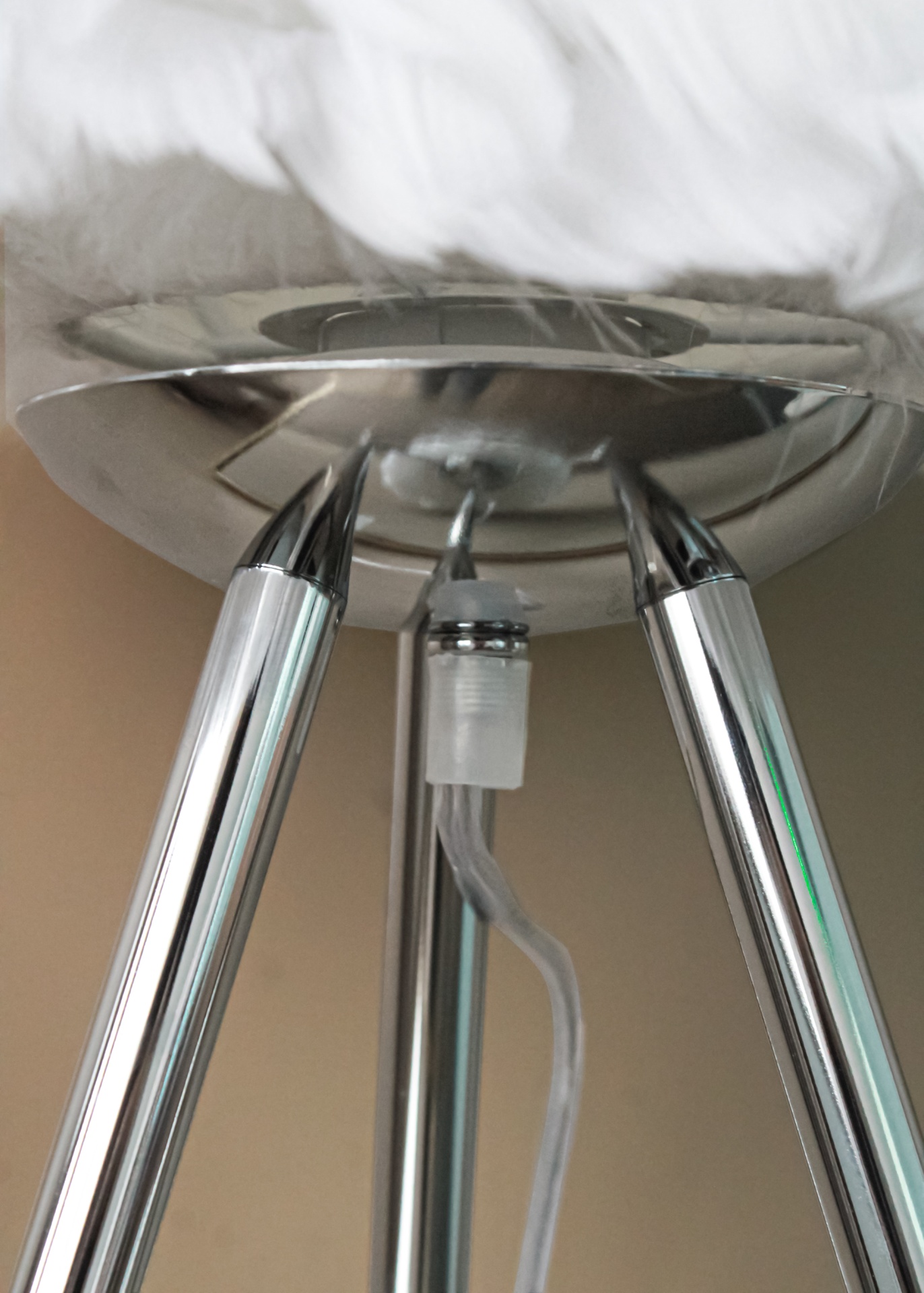 Base metálica cromada de suporte com três pés e cabo transparente