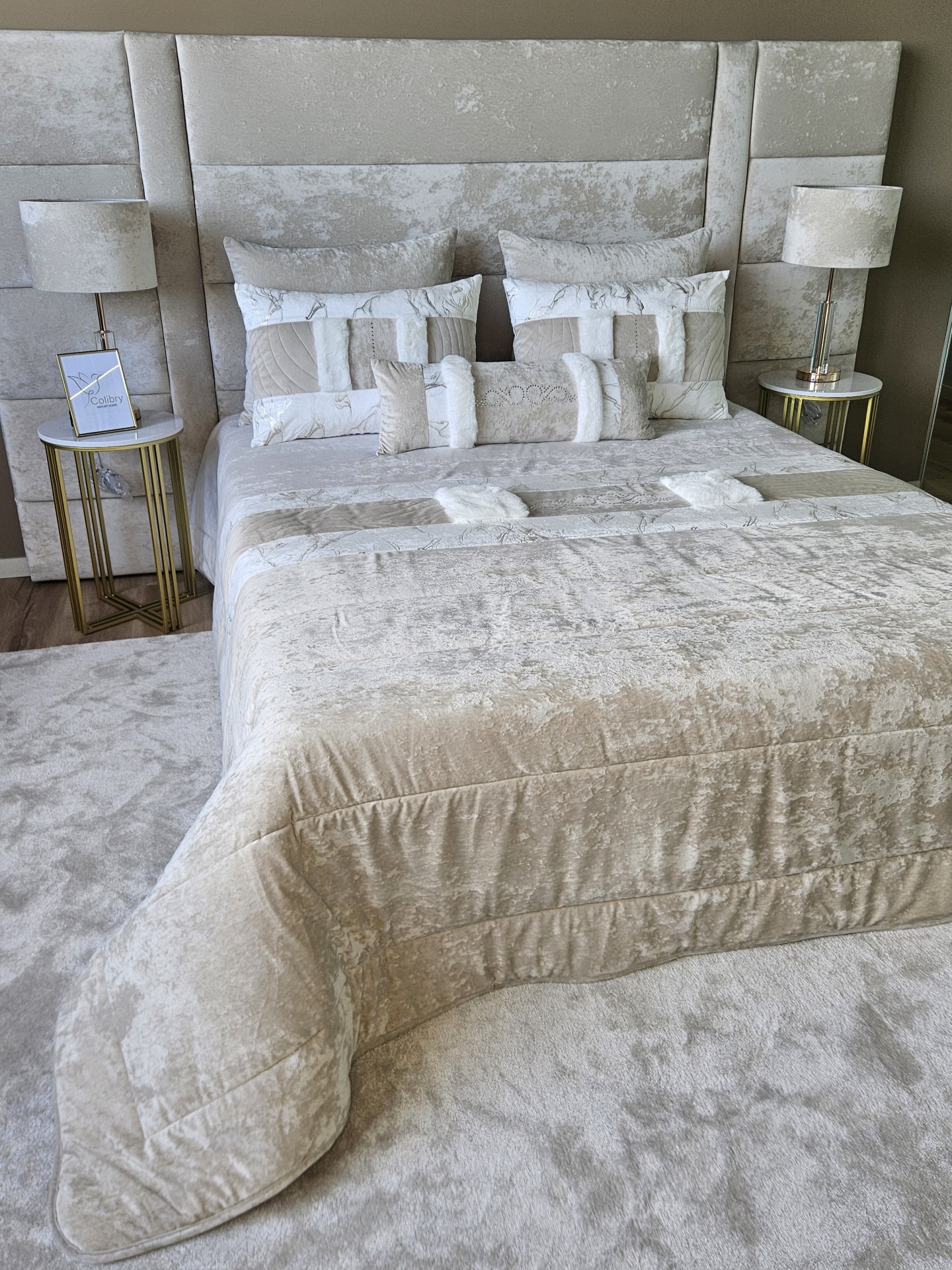 Edredão em Veludo Ref: Nepal Creme Cama de casal estofada com roupa de cama bege e branca e mesas de cabeceira com candeeiros em quarto