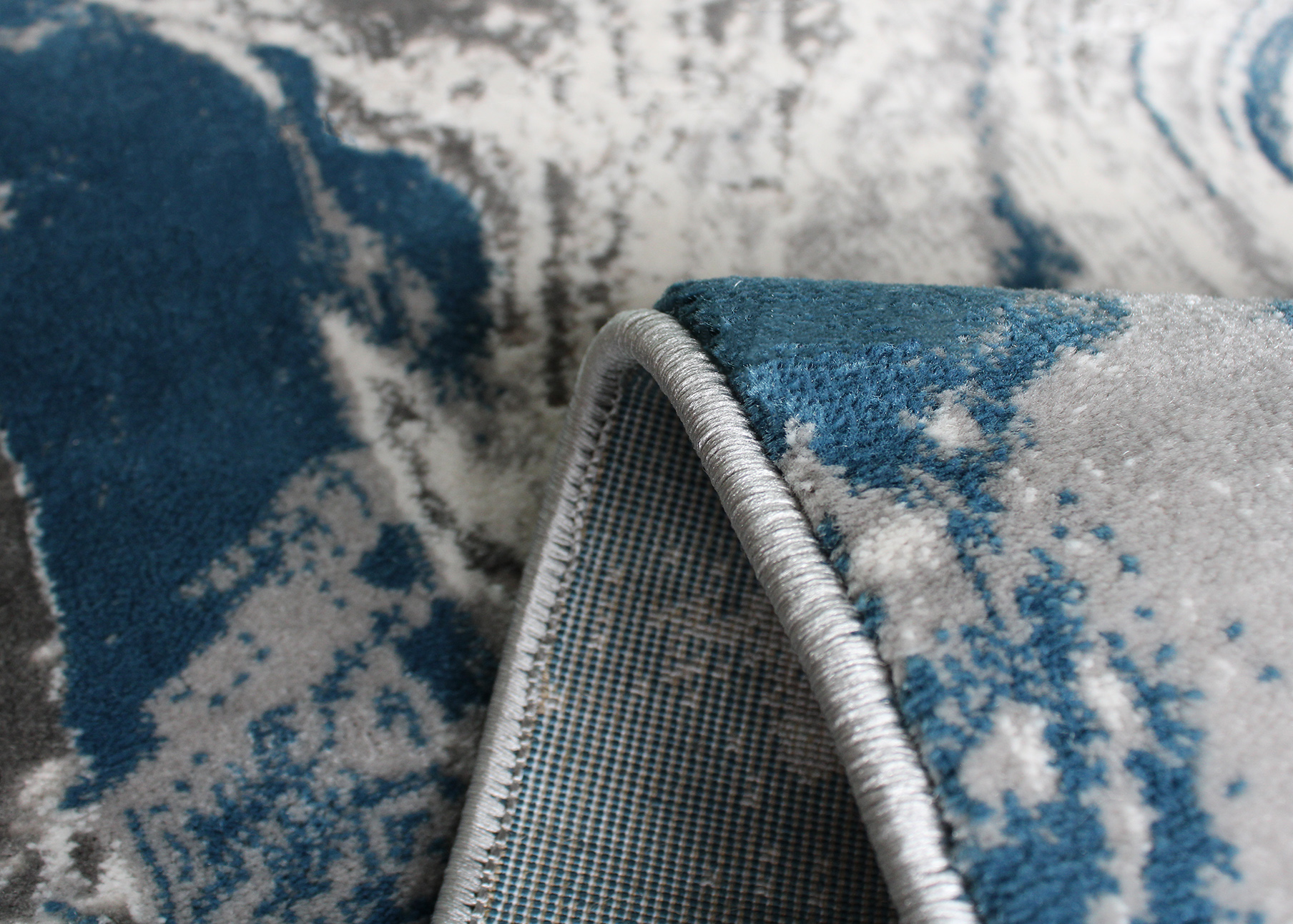 tapete azul e cinza com padrão abstrato e costura visível