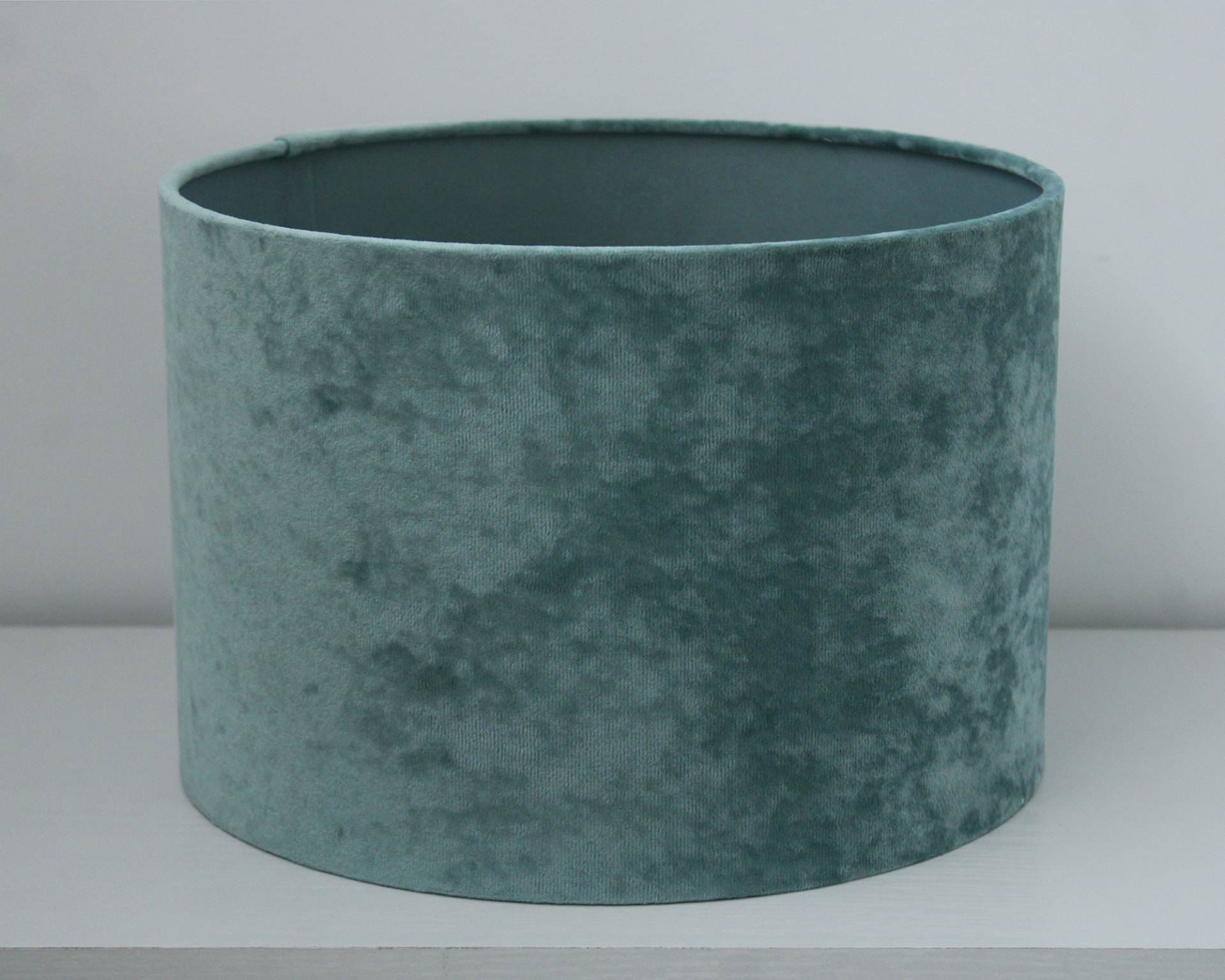 Cúpula de abajur verde azulado de veludo em superfície branca