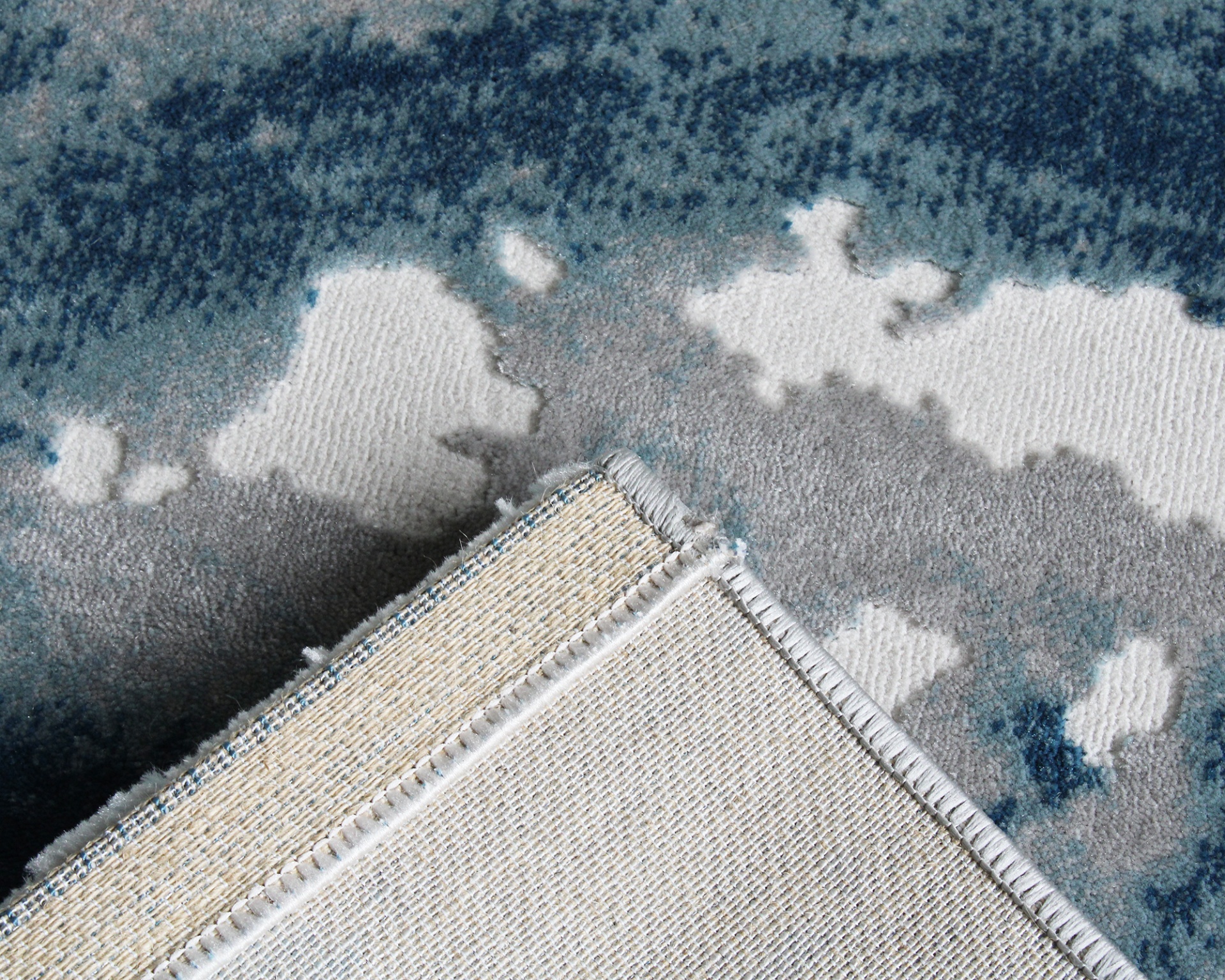 Tapete azul, cinza e branco com padrão abstrato e verso em trama bege