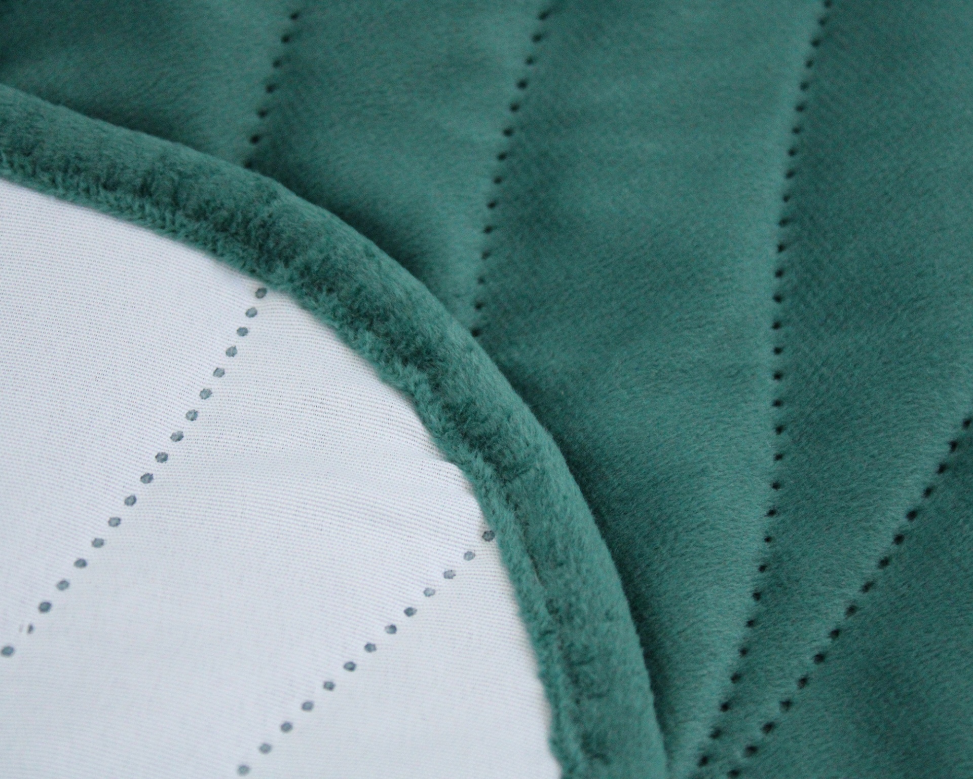 Cobertor verde com padrão ondulado e borda felpuda