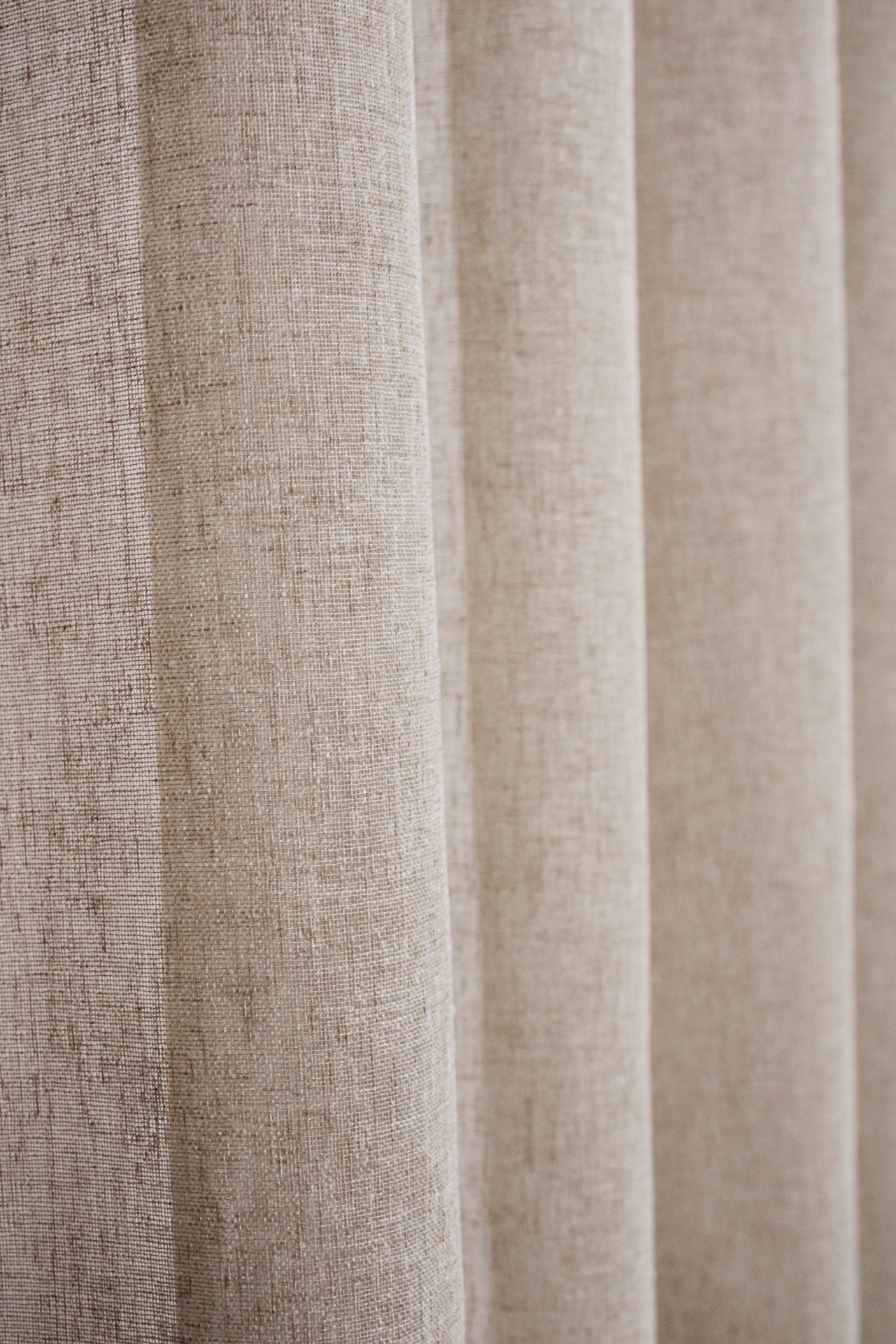 Cortina bege com textura fina em pregas verticais