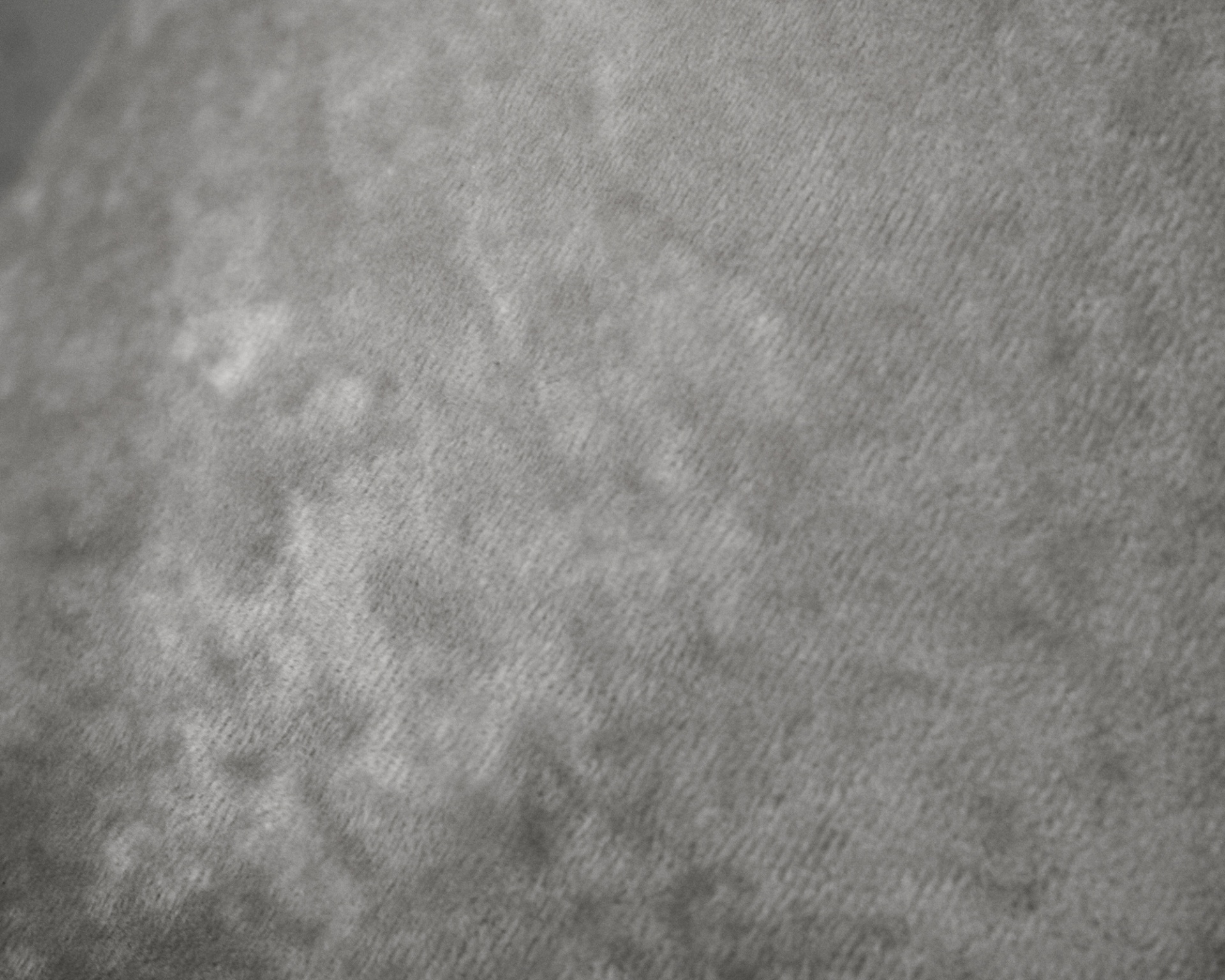 Tecido cinzento aveludado com textura e padrão suave irregular