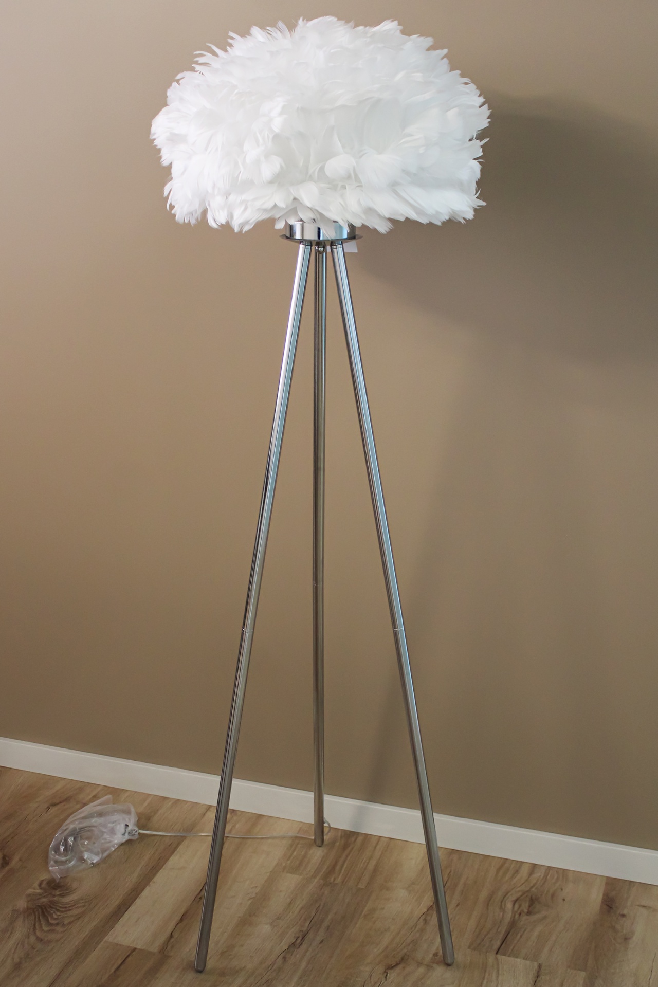 Candeeiro de pé com cúpula de penas brancas e base tripé metálica prateada