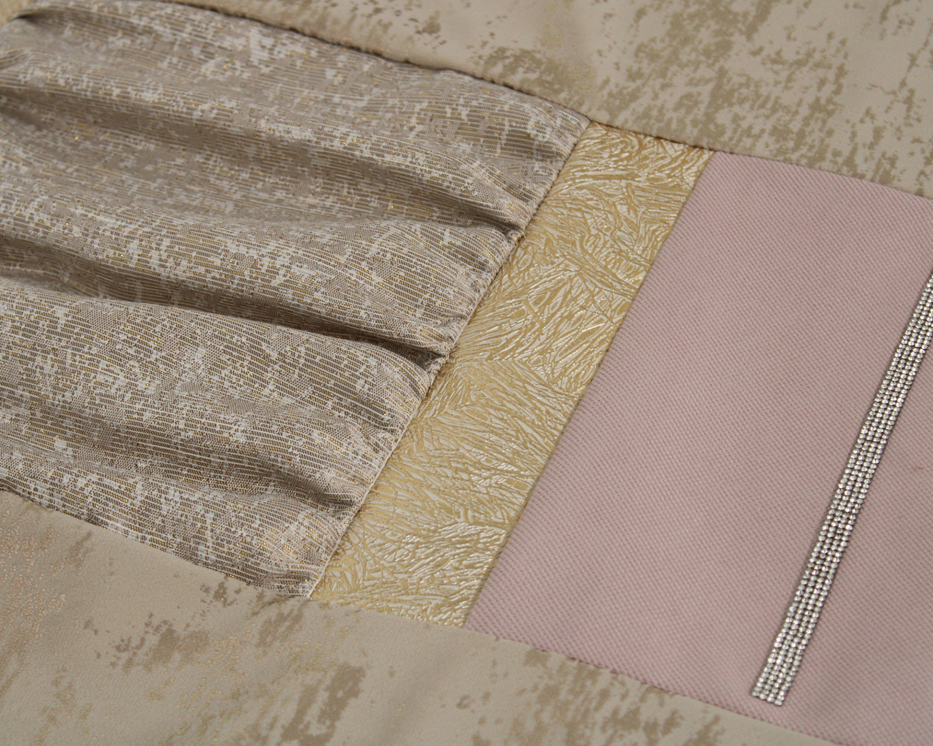 Tecidos em beige, rosa e dourado com texturas diferentes e faixa com brilho