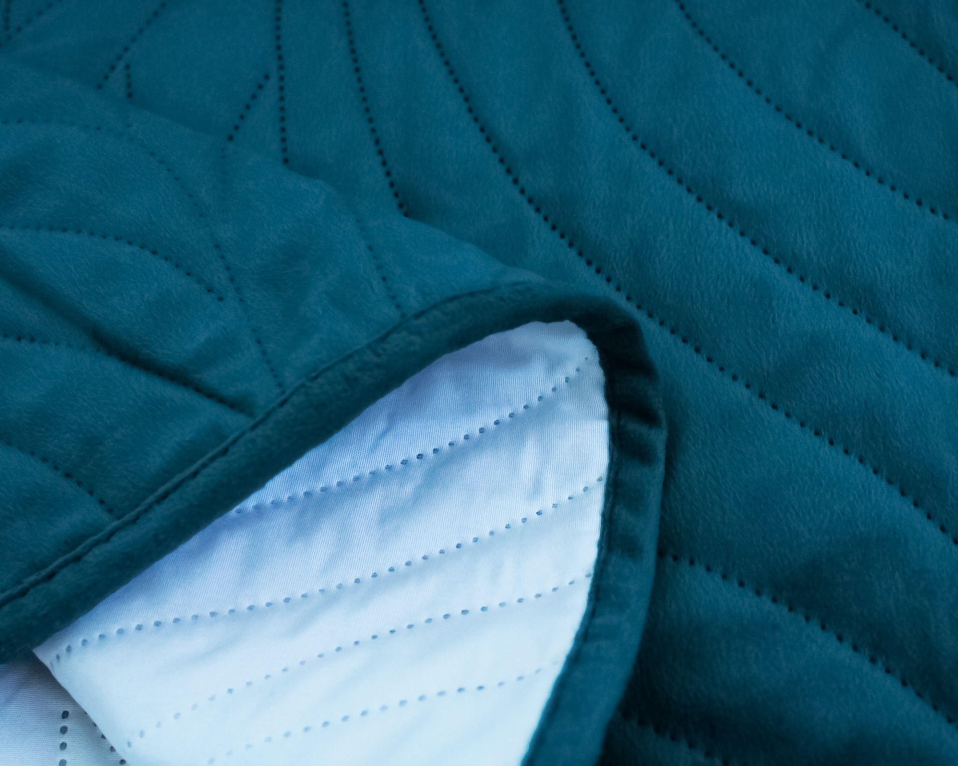 Têxtil acolchoado azul escuro e branco com padrão de linhas diagonais