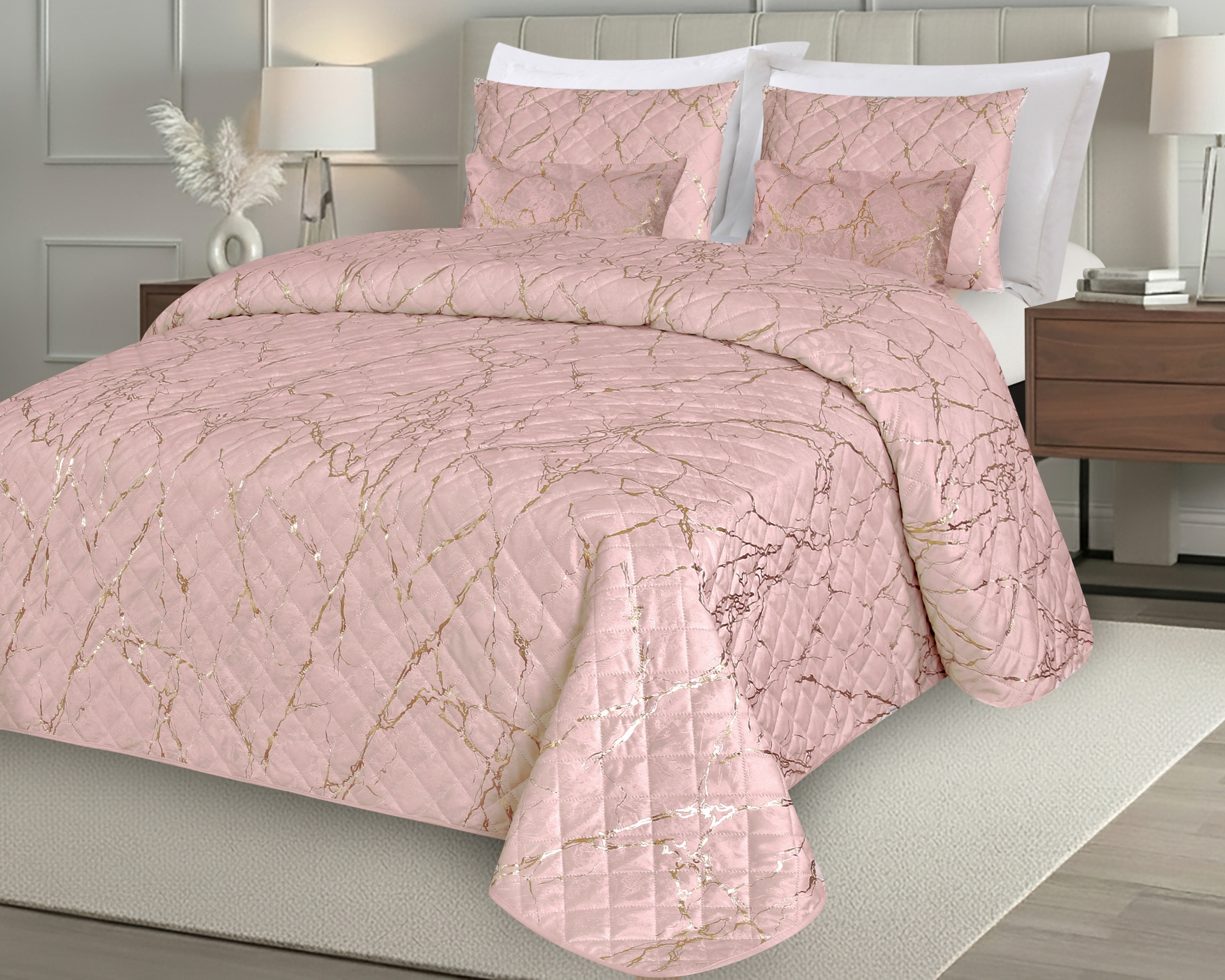 Colcha rosa com padrão dourado marmorizado e almofadas na cama.