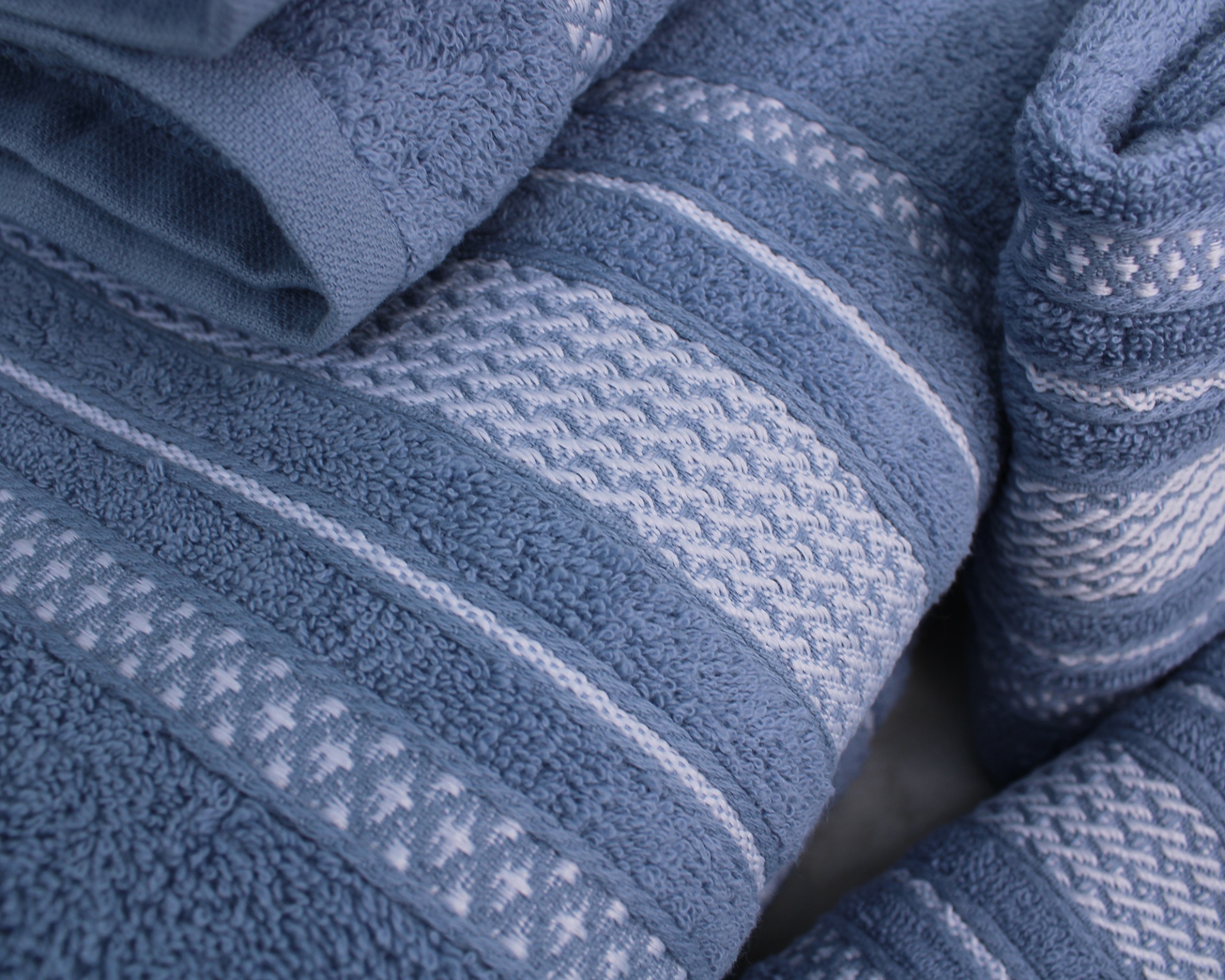 Toalhas azuis com padrões texturizados e riscas horizontais em tecido de banho