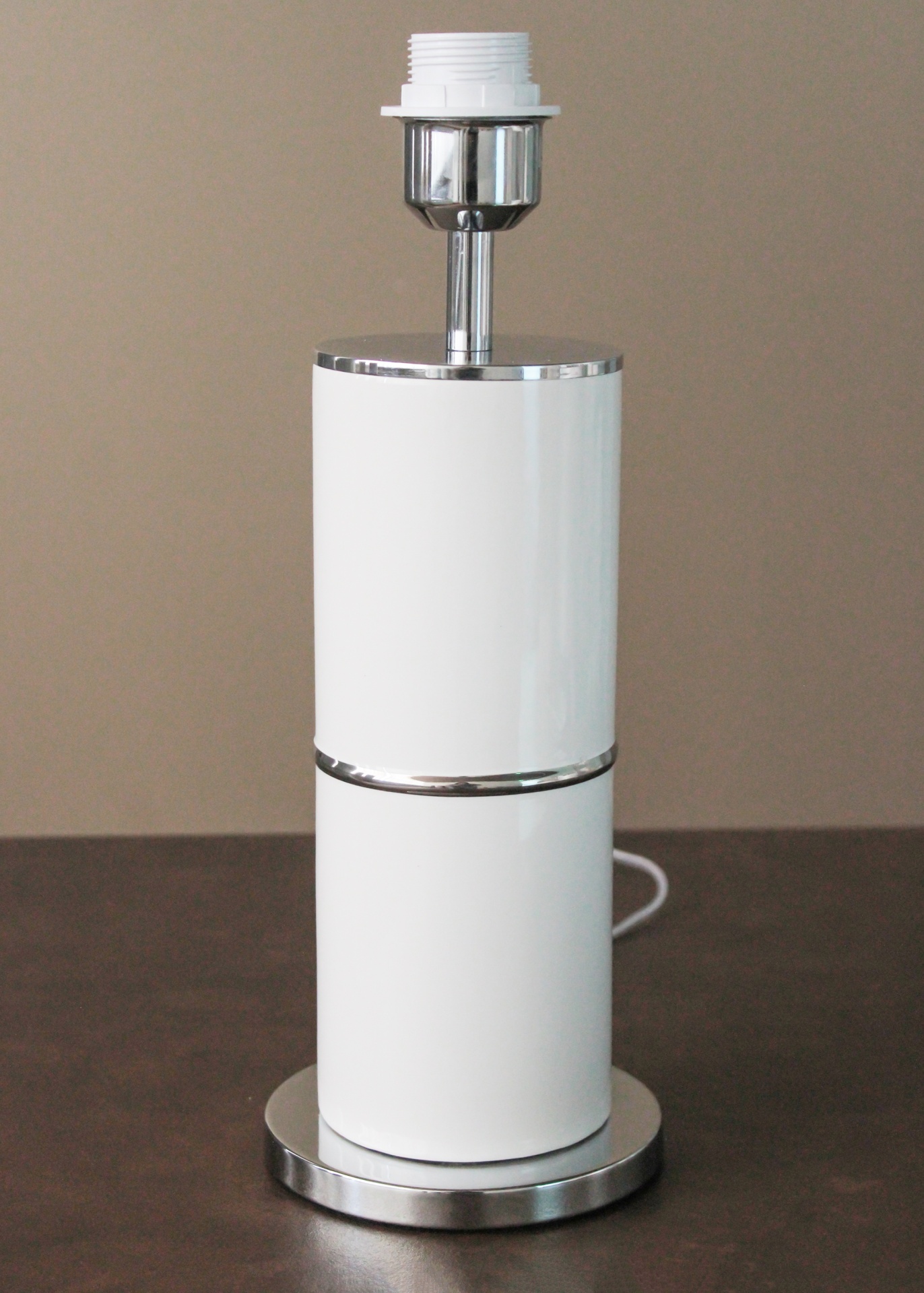 Base branca e cromada de candeeiro sobre superfície castanha