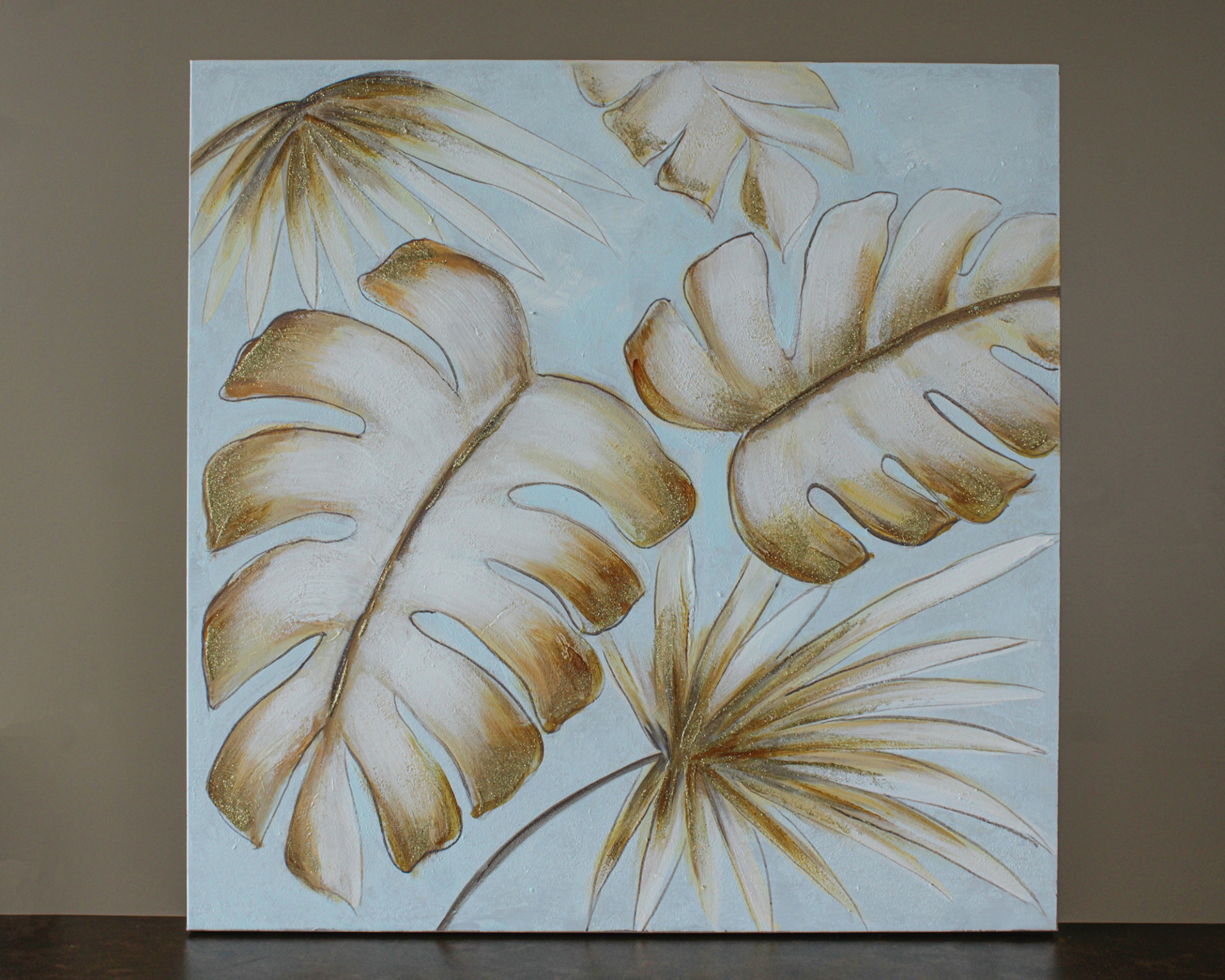 Tela decorativa com pintura de folhas bege e castanhas sobre fundo azul claro