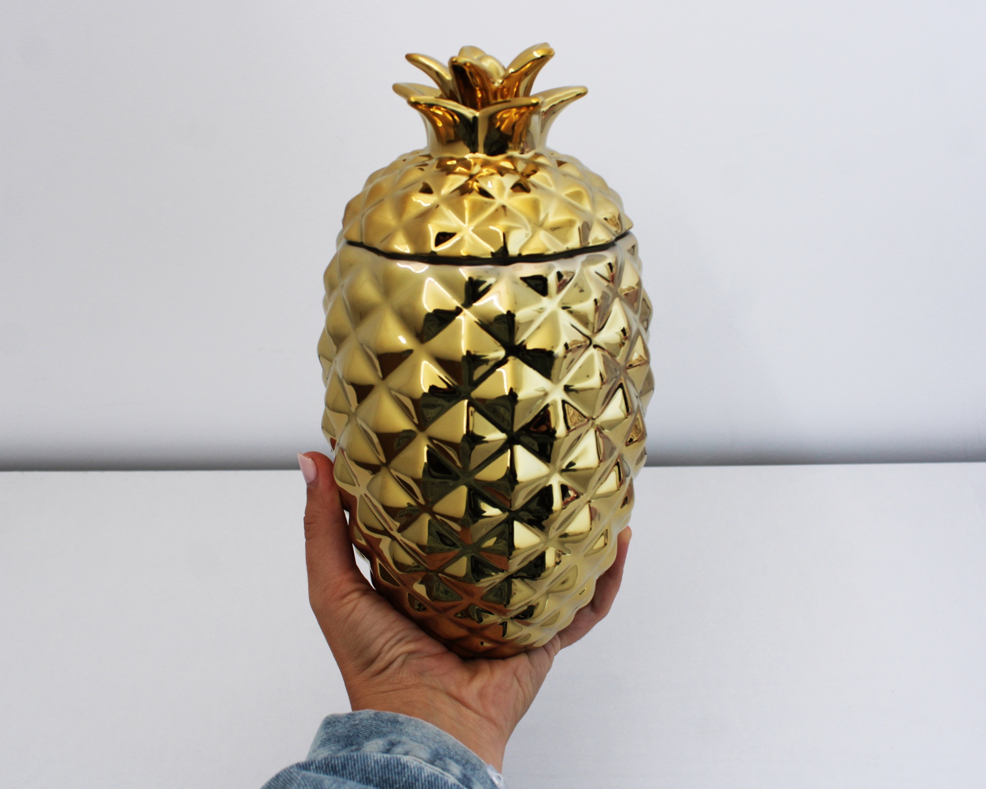 Recipiente decorativo dourado em forma de abacaxi com textura facetada