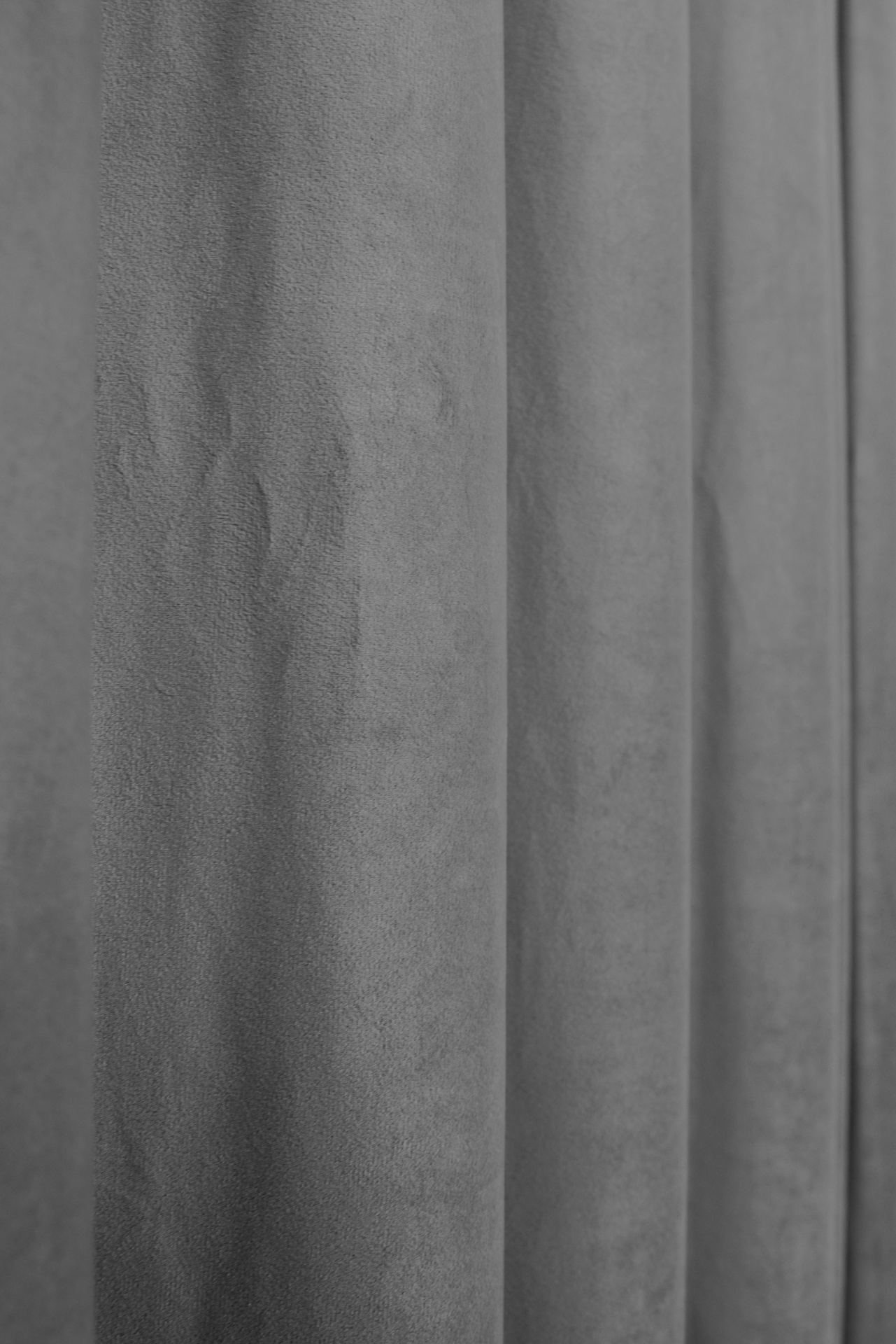 Cortina cinzenta com textura suave e dobras verticais