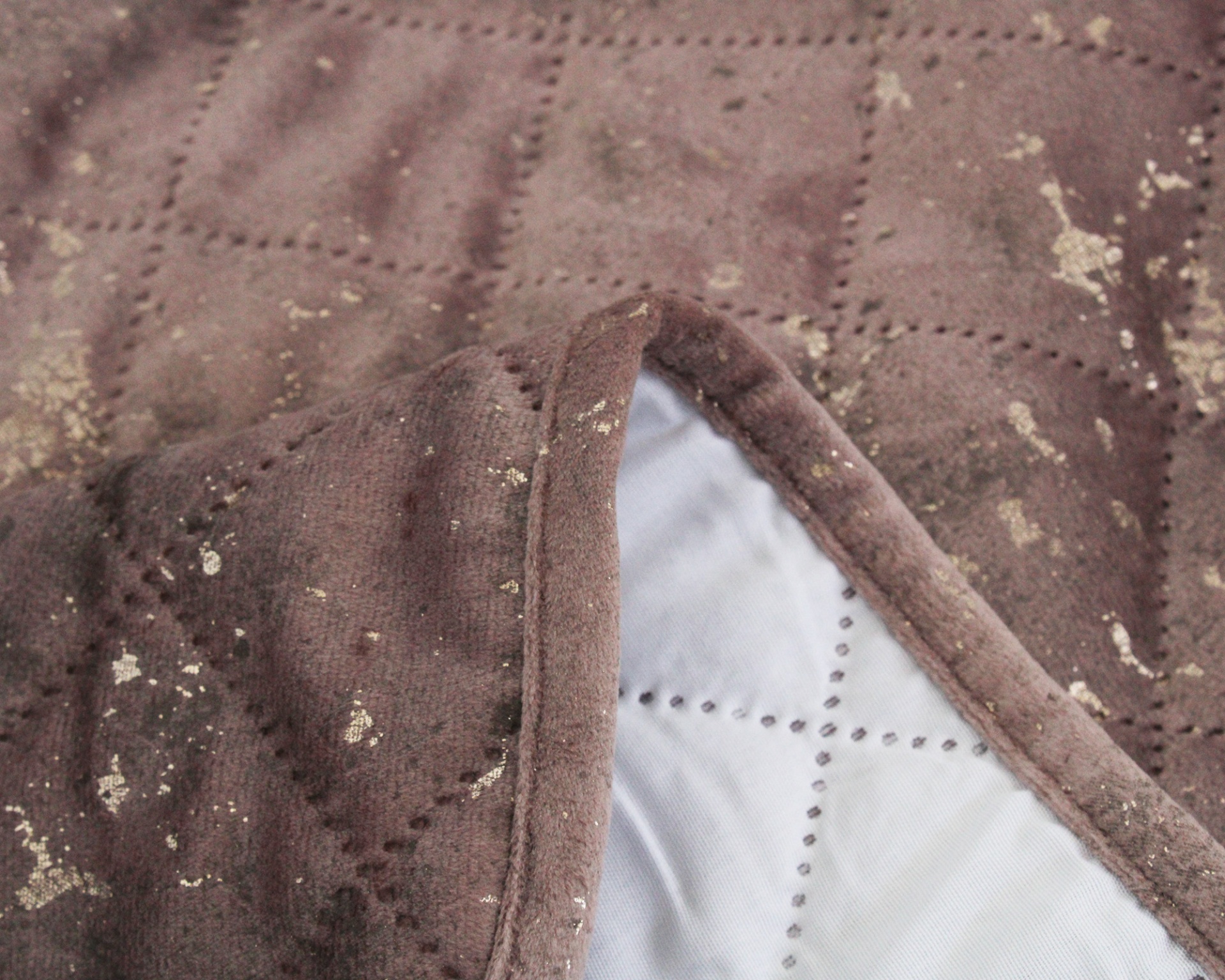 Manta castanha acolchoada com manchas e forro branco acolchoado