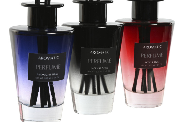 Três difusores de aroma em frascos de vidro coloridos com etiquetas pretas