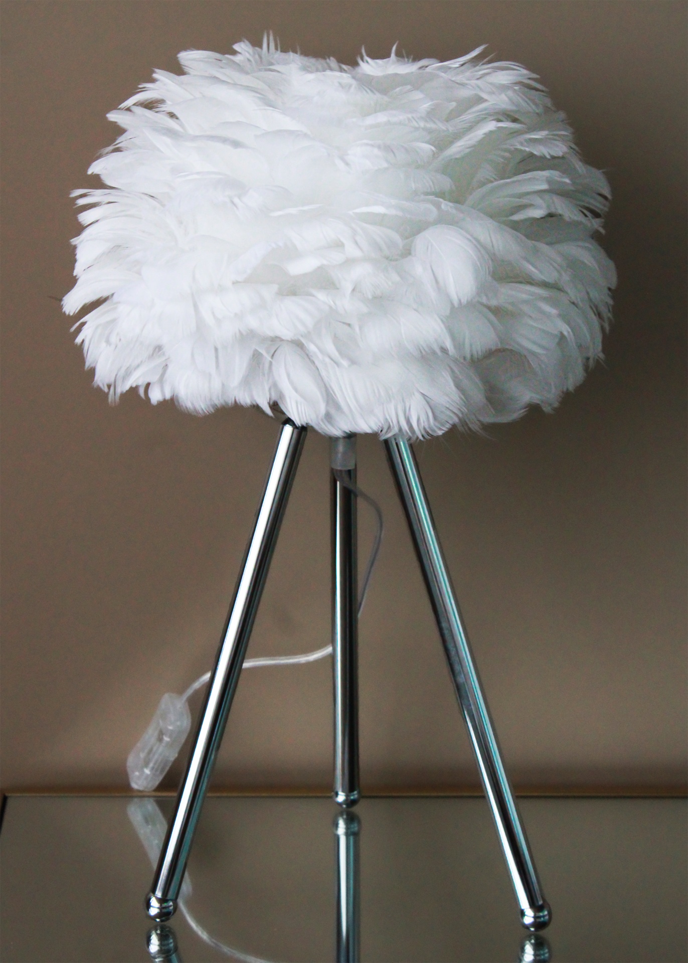 Candeeiro de mesa com penas brancas e base metálica cromada