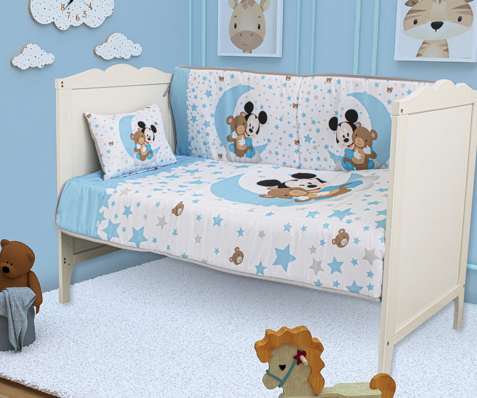Cama de criança com roupa de cama azul e branca com desenhos de ursinhos a dormir na lua e estrelas