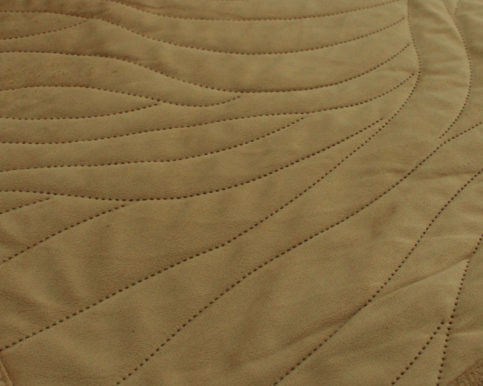 tecido bege com padrão ondulado e costuras finas em relevo