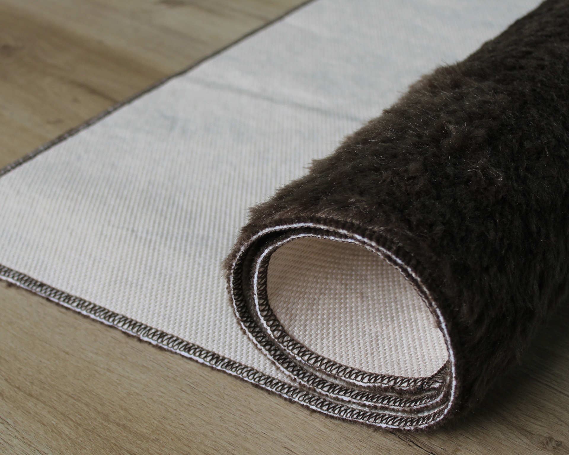 Tapete de pelo alto castanho escuro enrolado com base antiderrapante cinza claro