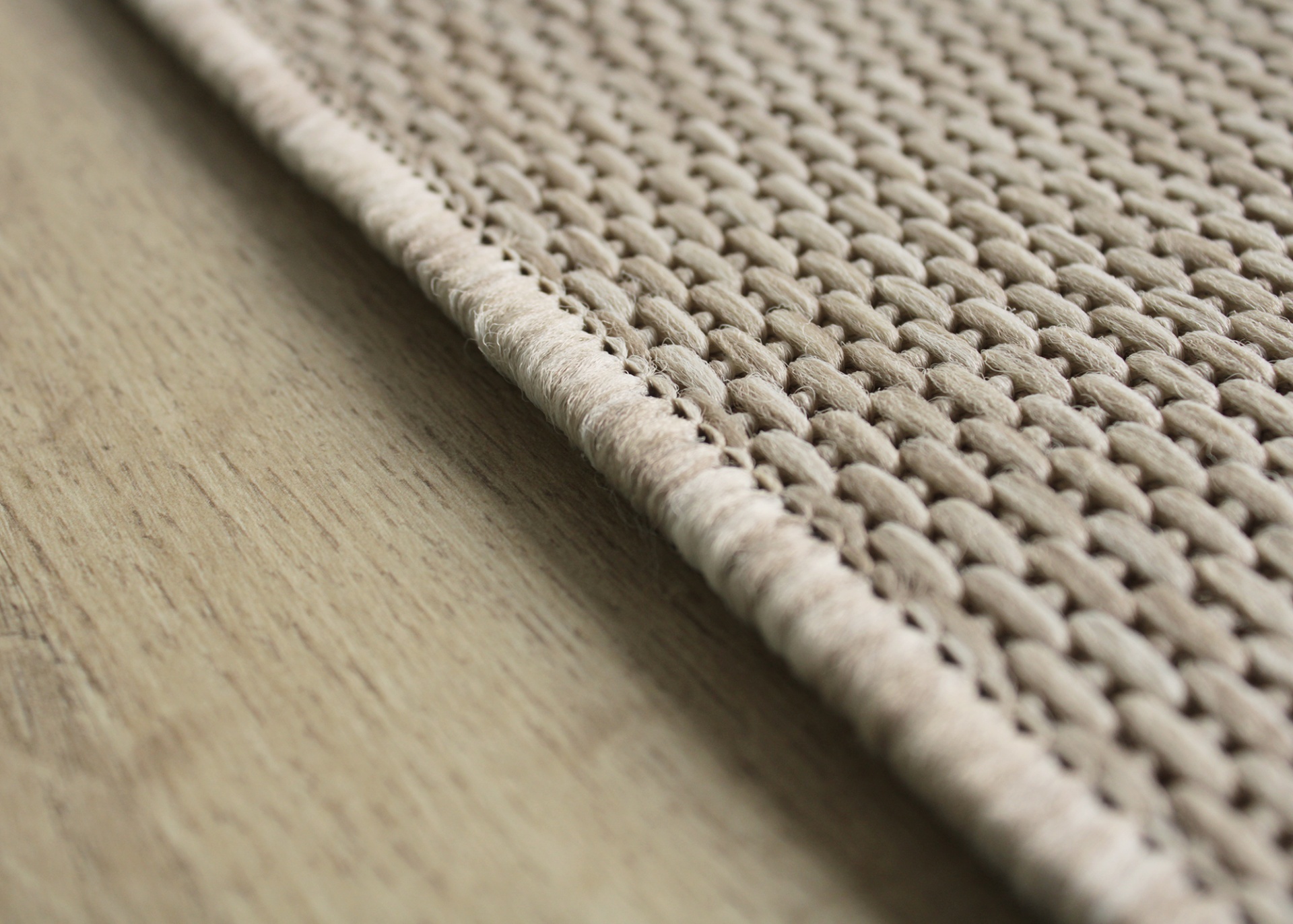 Tapete bege trançado sobre chão de madeira clara