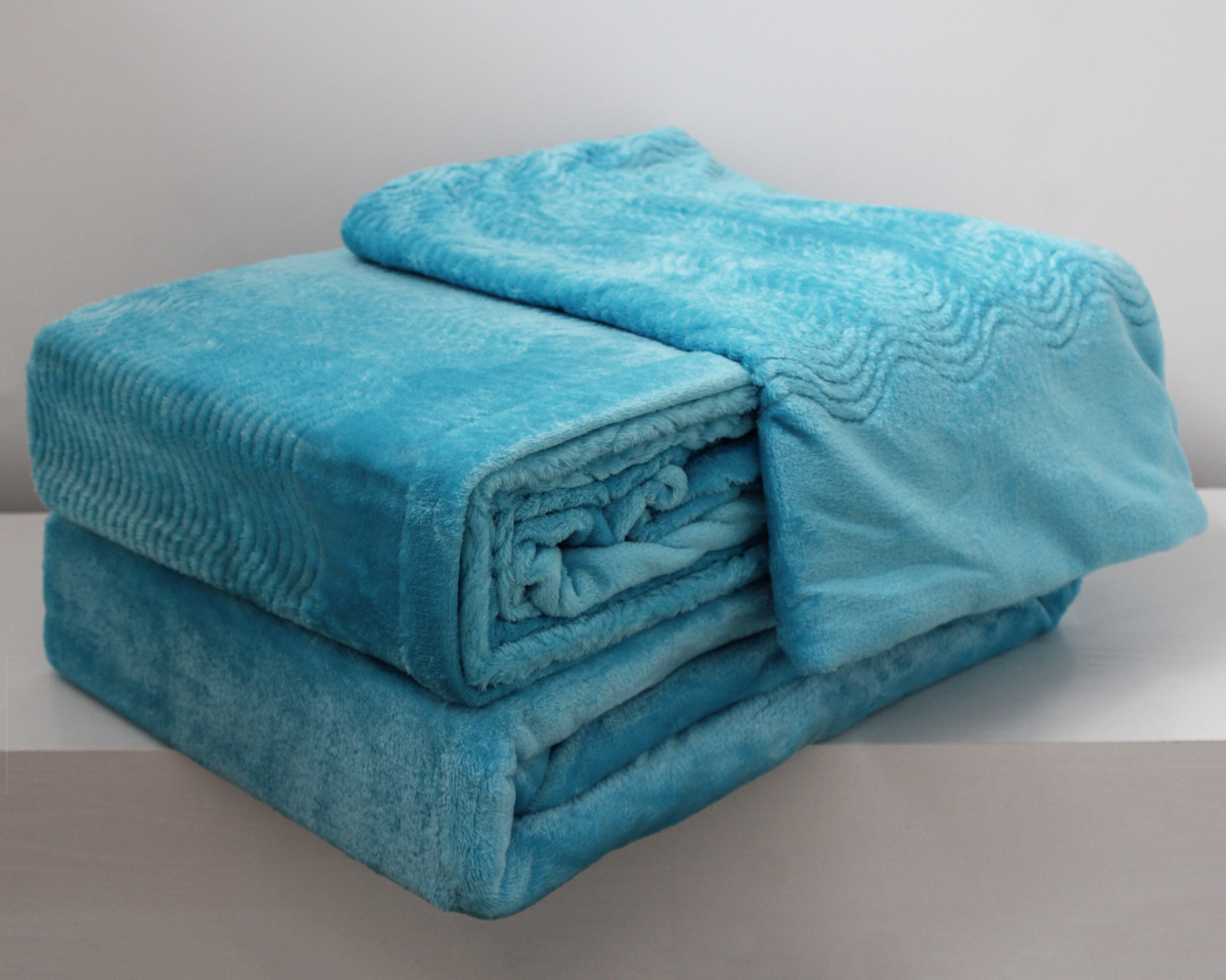 Cobertor azul macio dobrado com padrão ondulado