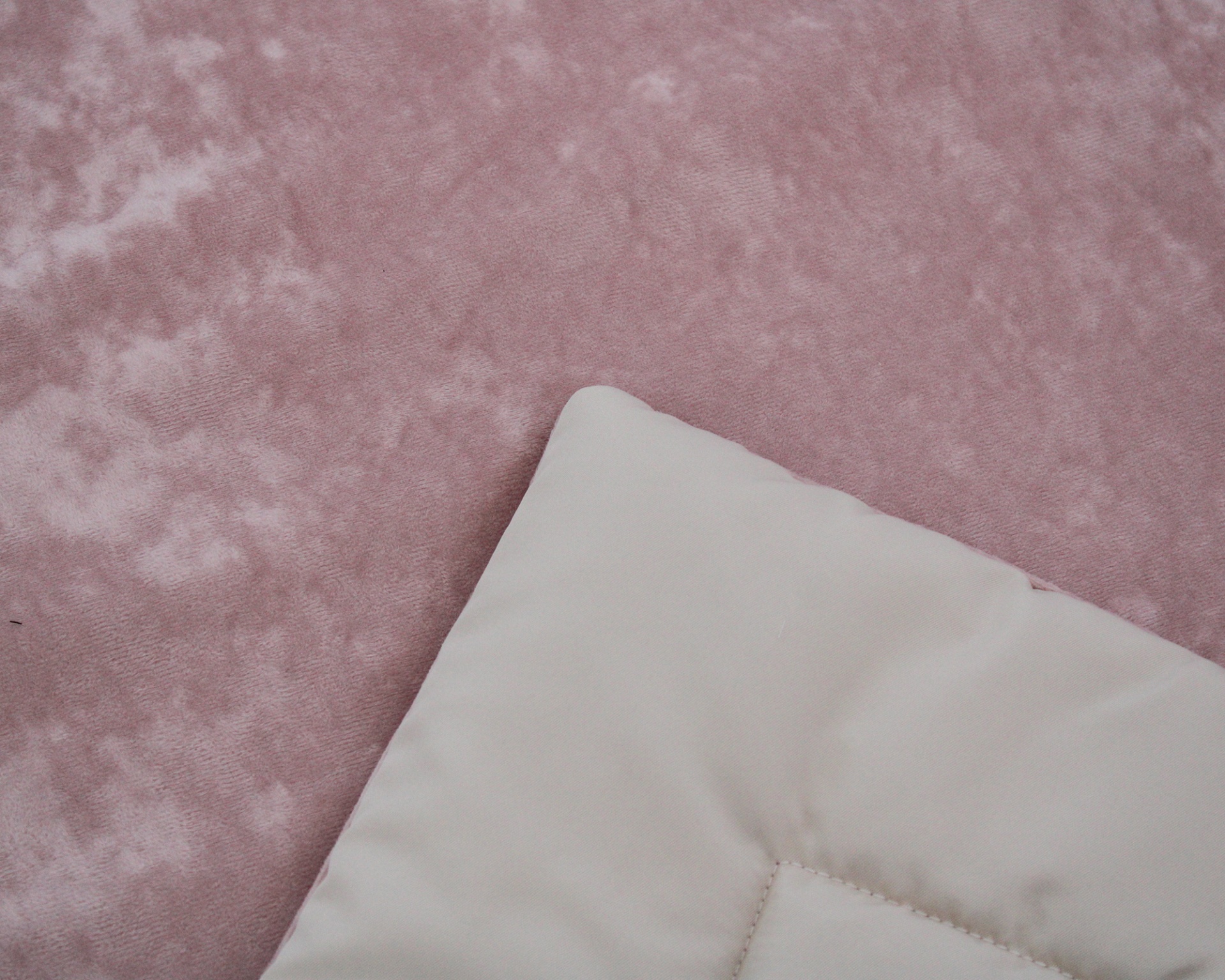 tecido rosa com textura aveludada e canto de almofada bege