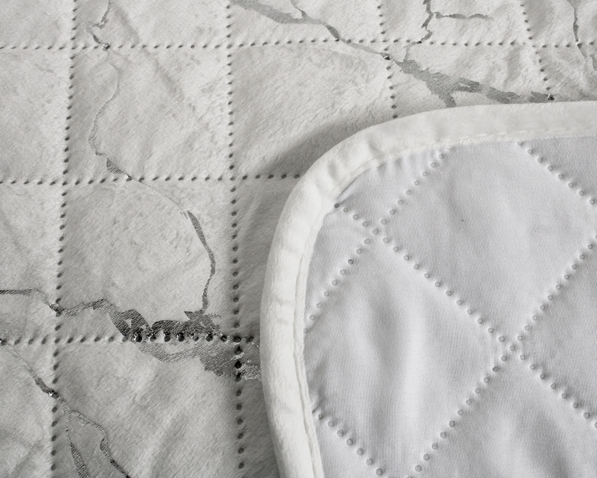 Pano têxtil branco com padrão em relevo e decoração prateada