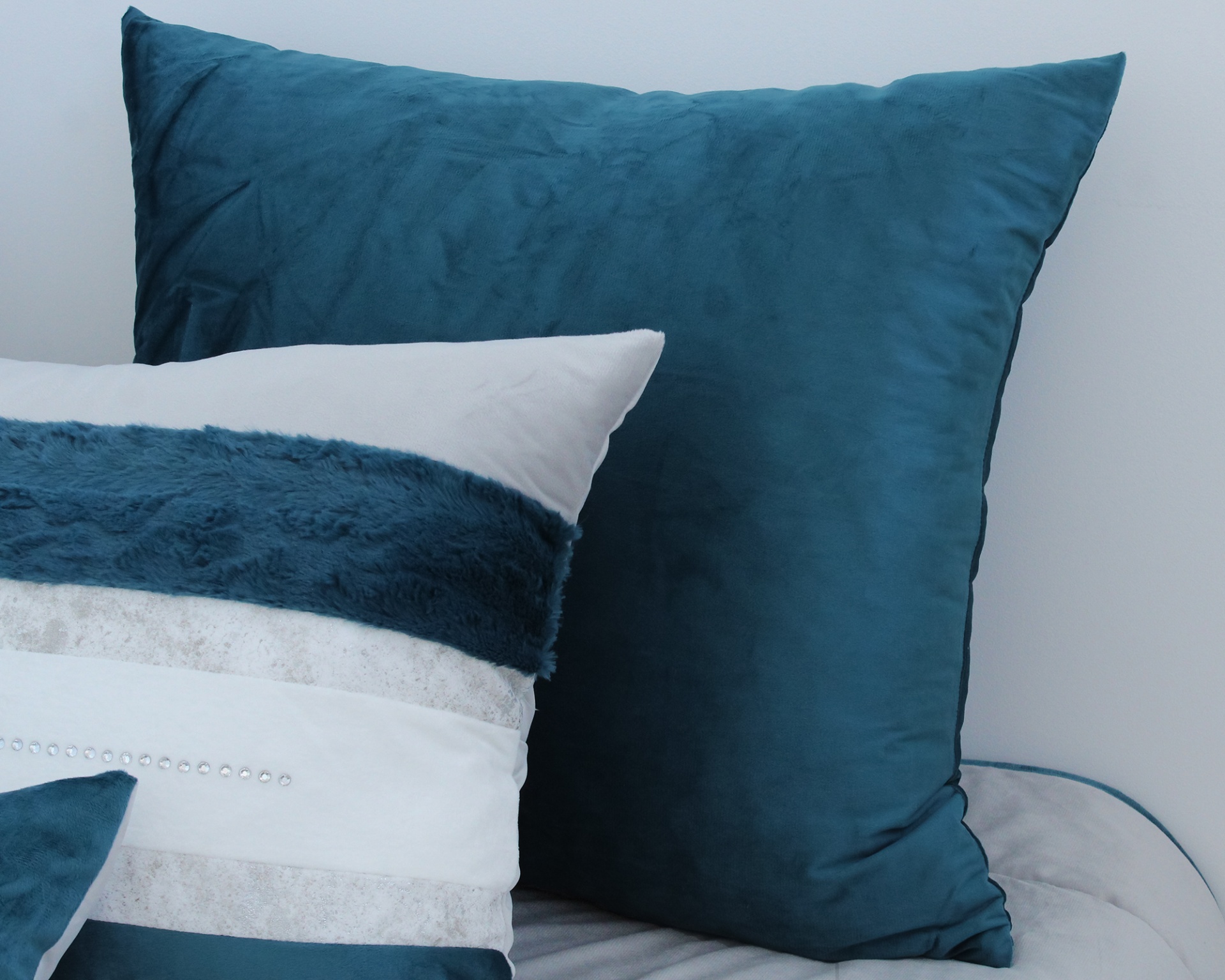 Três almofadas decorativas em cama cinza