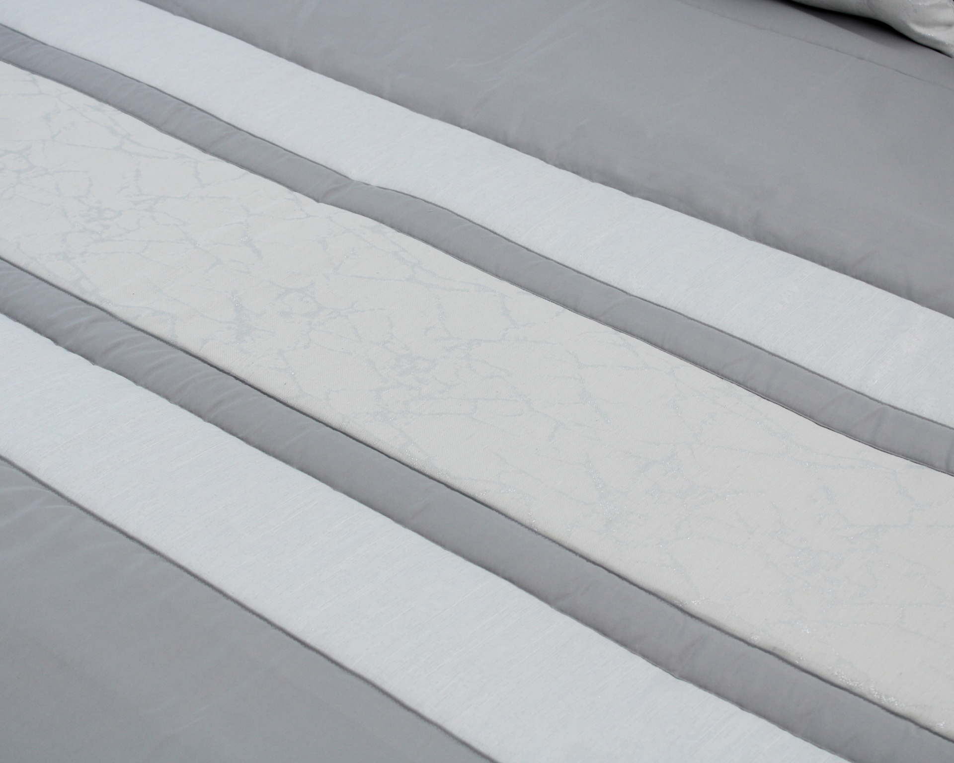 Roupa de cama cinza com listras brancas e padrão floral subtil