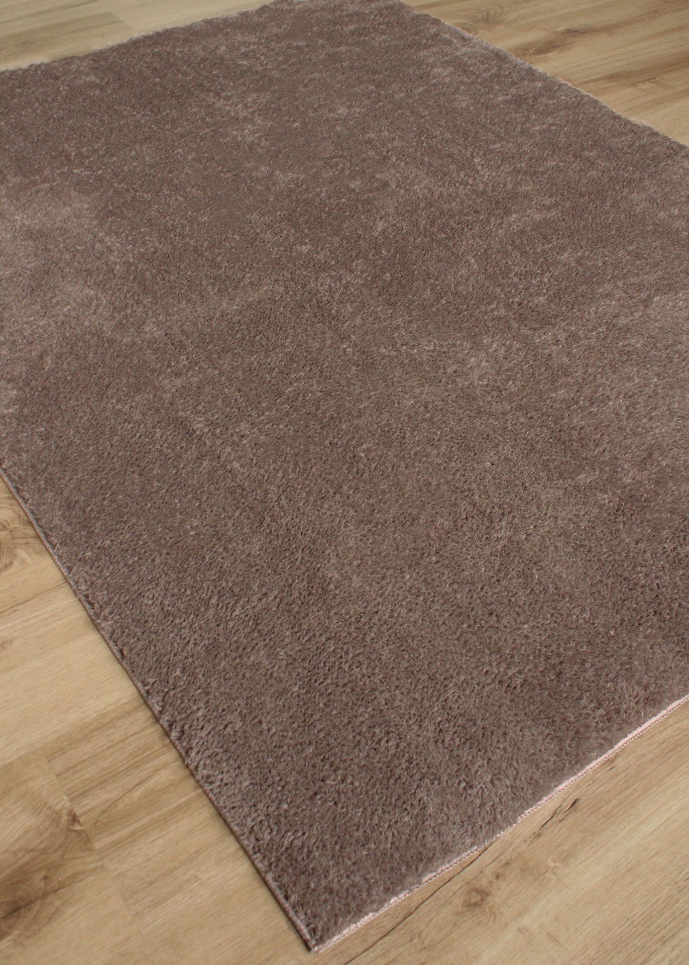 Tapete castanho claro macio sobre chão de madeira