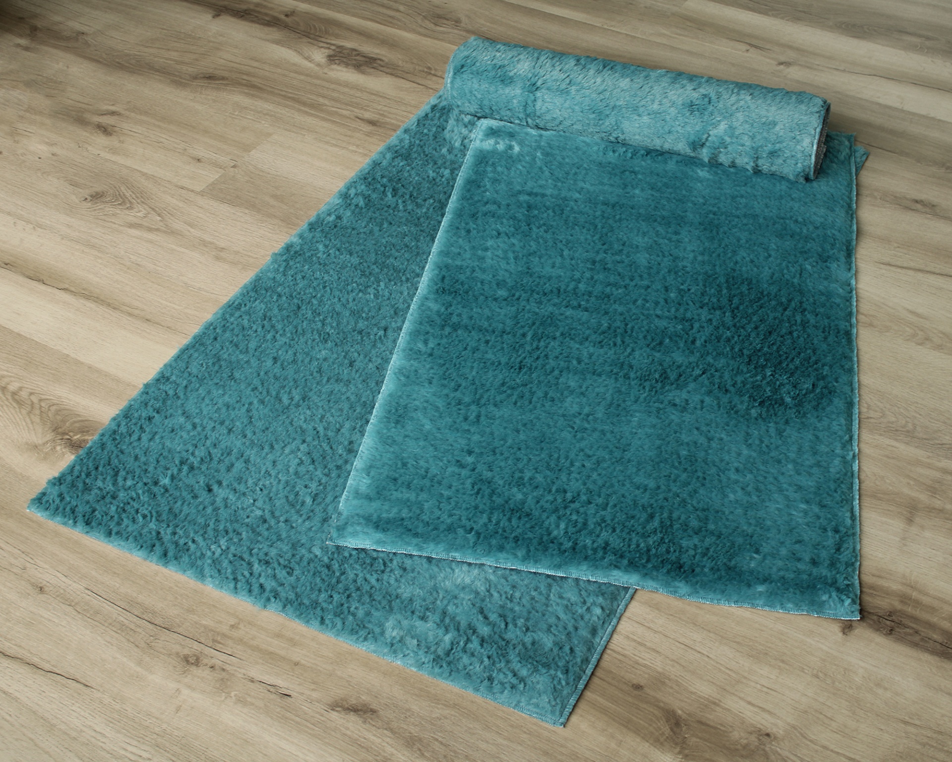 Tapete azul turquesa aveludado sobre chão de madeira clara