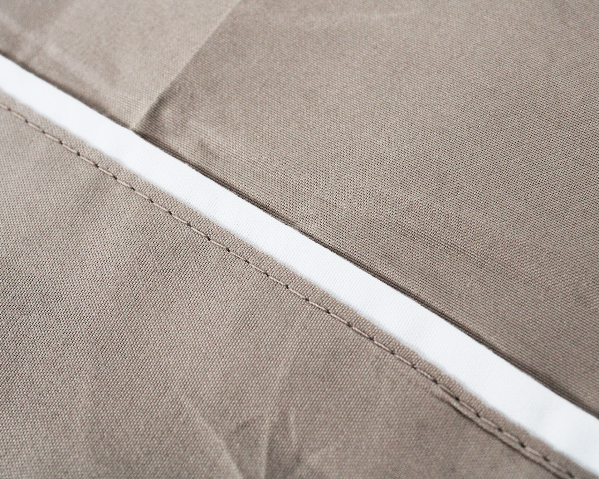 Tecido bege com faixa branca e costura detalhada