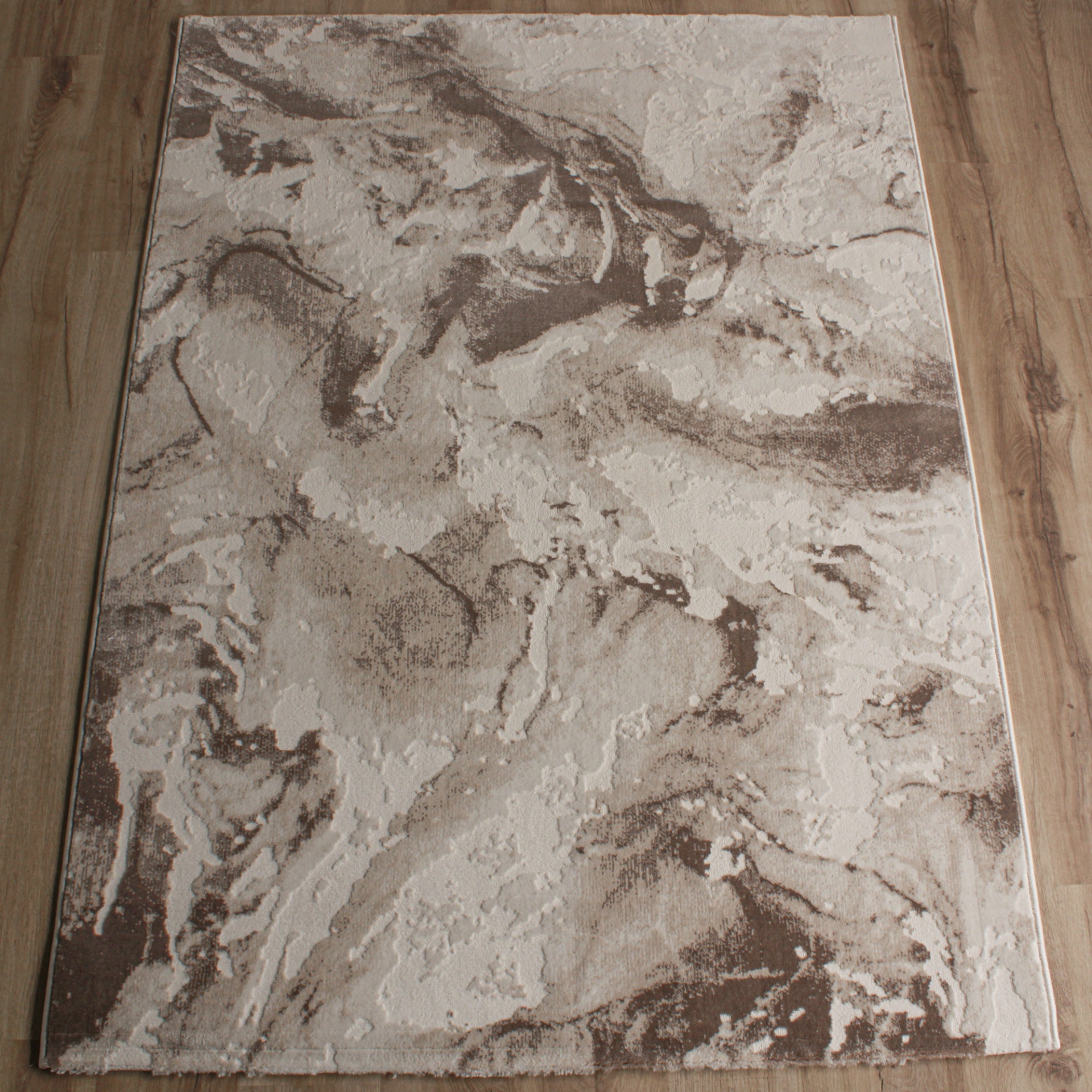 Tapete bege e castanho com padrão abstrato sobre chão de madeira clara