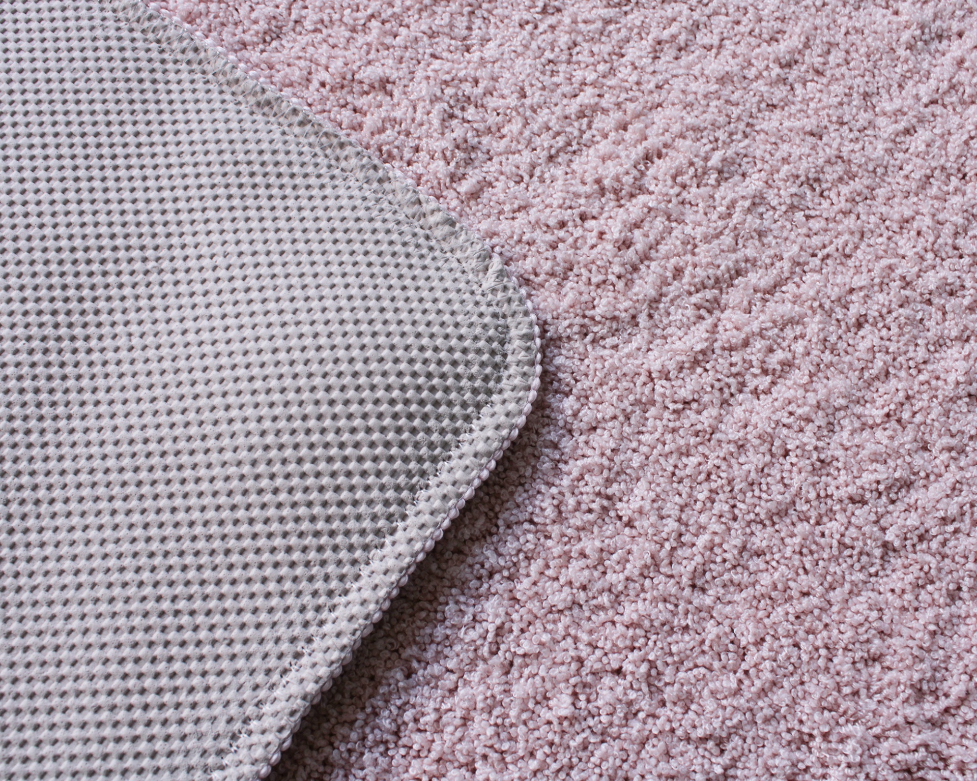 Tapete cor-de-rosa claro felpudo com canto de tapete cinzento em padrão malha